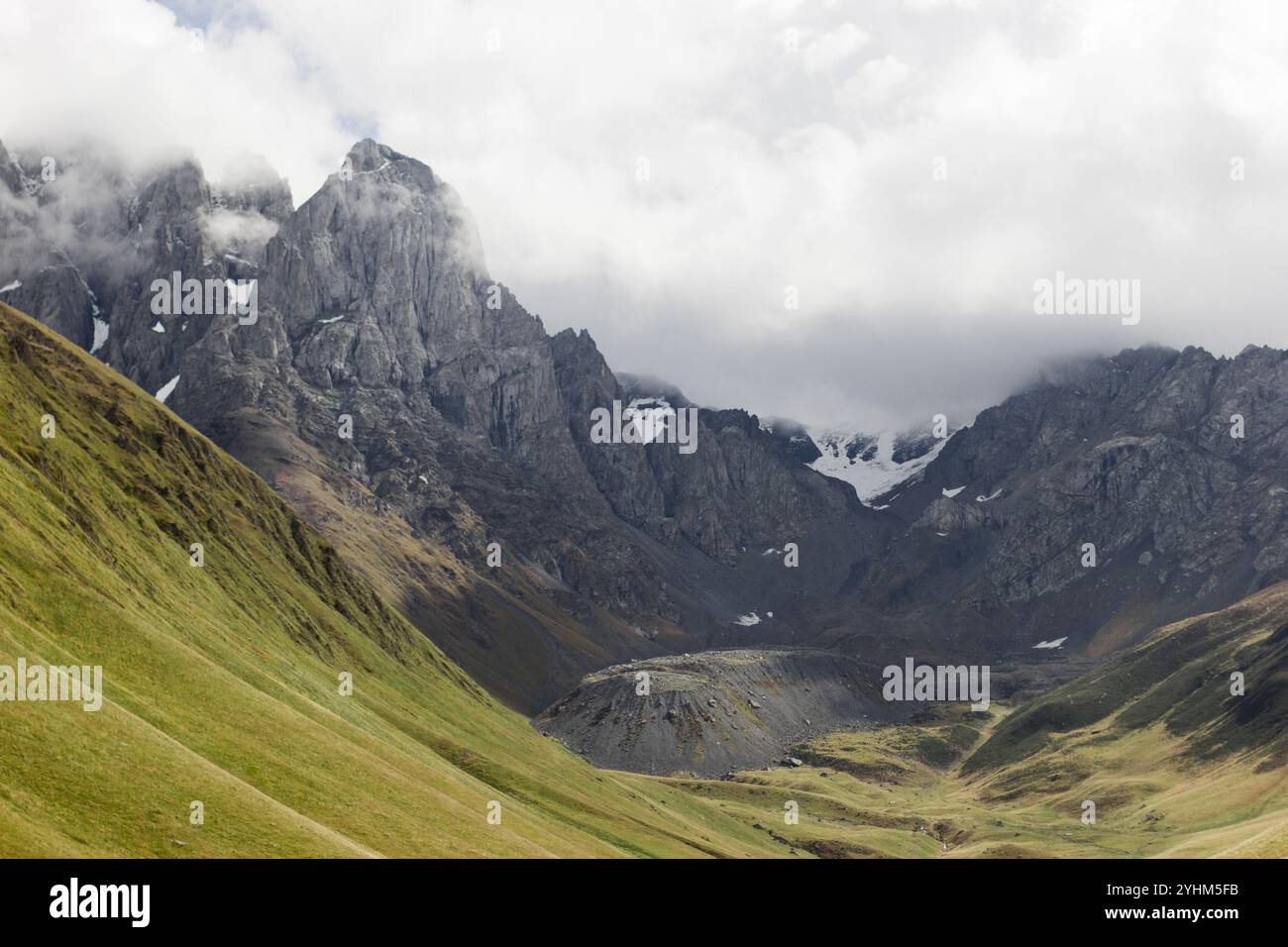 Dieses horizontal ausgerichtete Foto zeigt die majestätischen Kaukasus-Berge in Georgien während der Herbstsaison. Im Vordergrund ist rollend gr Stockfoto