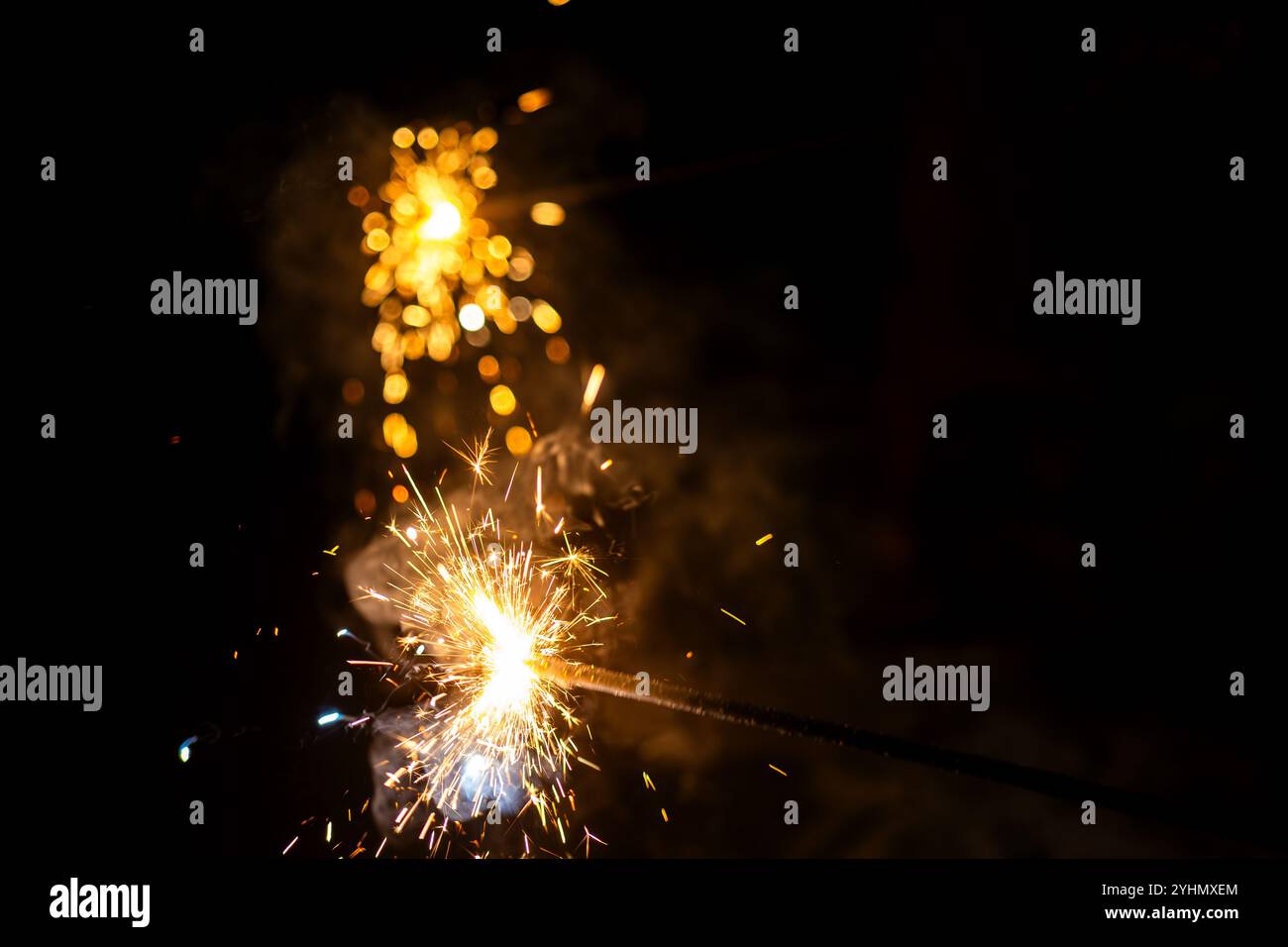 Goldene Funken tanzen in der Nacht und schaffen ein magisches Ambiente. Perfekt für Feiern und festliche Designs. Stockfoto