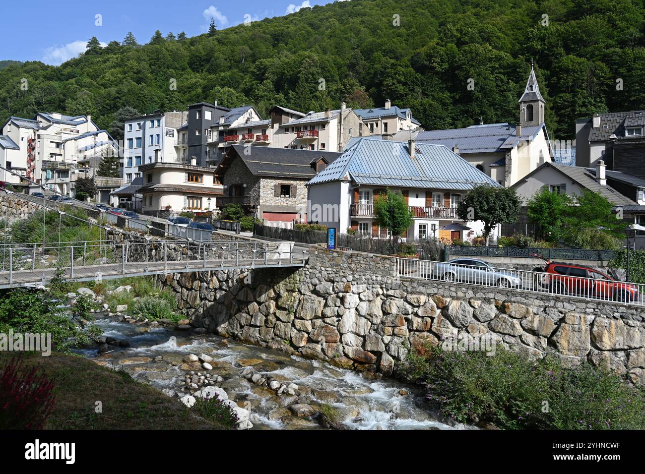 Fußgängerbrücke über den Fluss Bastan und das Bergdorf und die Kurstadt Barèges Hautes-Pyrénées Pyrenäen Frankreich Stockfoto