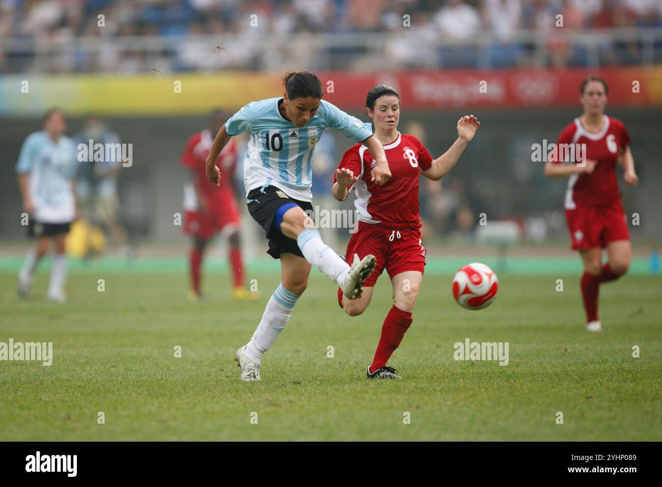 TIANJIN, CHINA - 6. AUGUST: Mariana Coronel von Argentinien (10) schlägt einen Schuss, als Diana Matheson von Kanada (8) während eines Gruppenspiels beim Olympischen Frauenfußballturnier in Peking am 6. August 2008 im Tianjin Olympic Sports Center Stadium in Tianjin, China, verteidigt. (Foto: Jonathan P. Larsen / Diadem Images) Stockfoto
