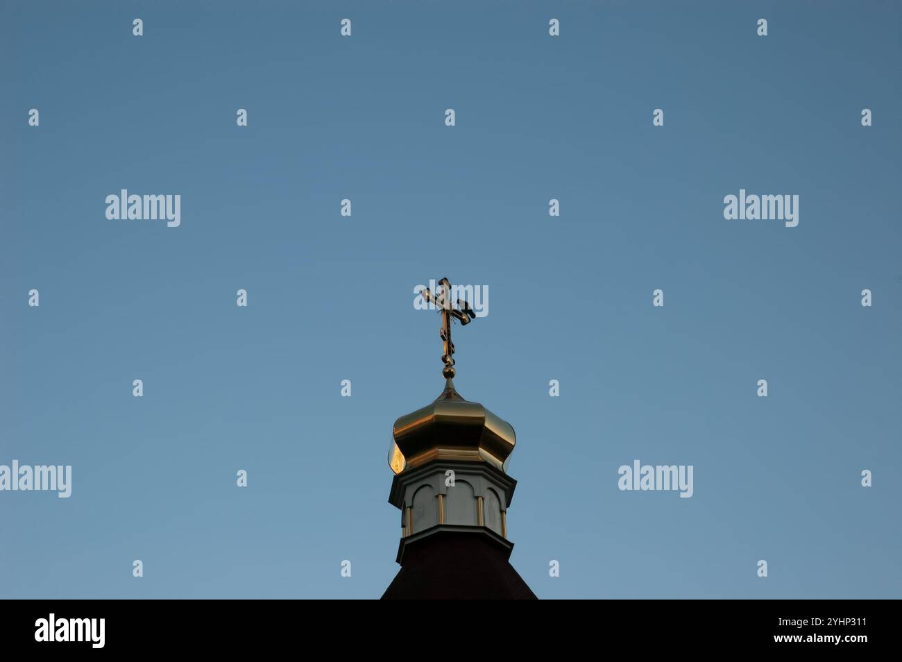 Eine Krähe sitzt auf einem Kirchenkreuz Stockfoto