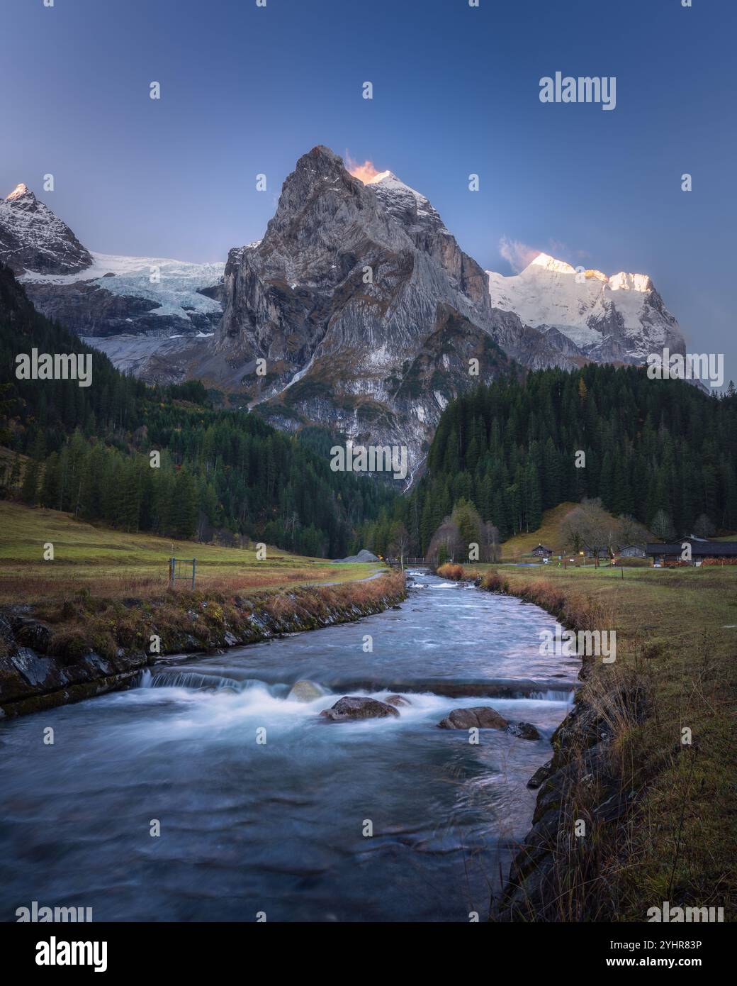 Schweizer Alpen im goldenen Licht: Bergbach und majestätische Gipfel Stockfoto