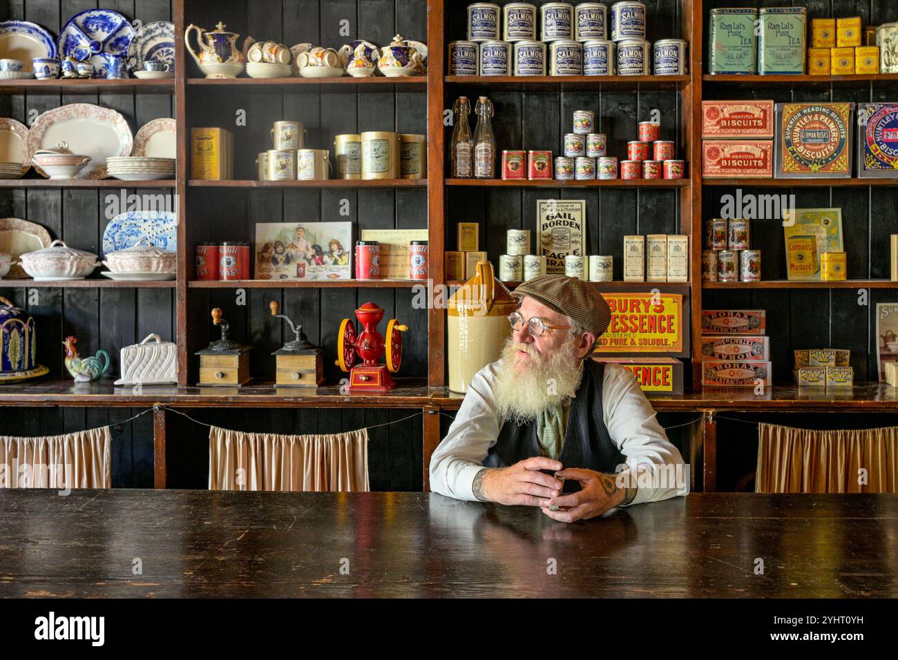 Älterer bärtiger Mann hinter der Theke, General Store, Fort Edmonton Park, Edmonton, Alberta, Kanada Stockfoto