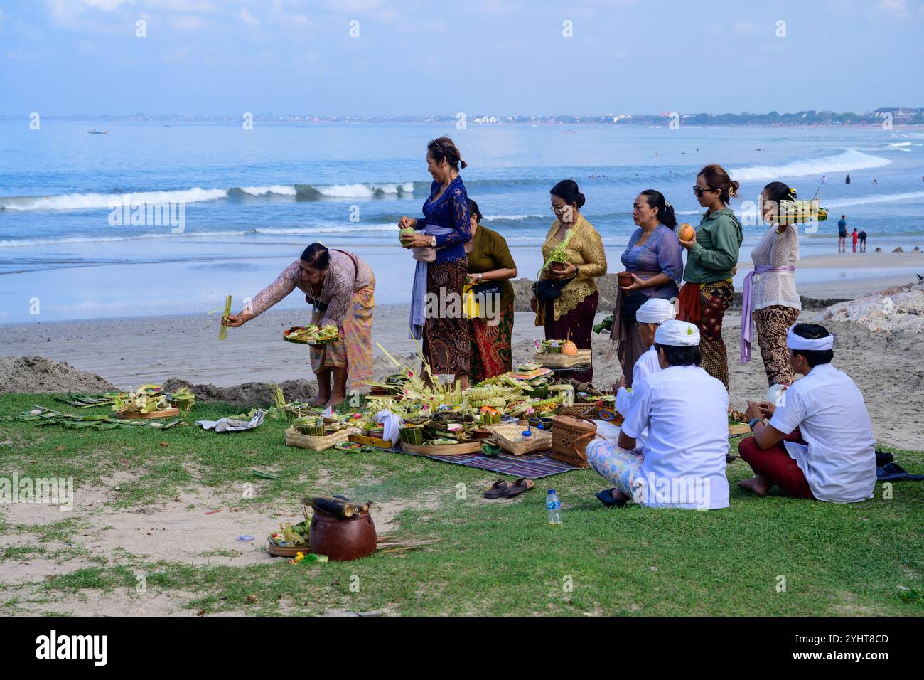 Kuta Beach, Bali, Indonesien - 8. November 2024: Religiöse hinduistische Zeremonie mit Frauen in traditioneller Kleidung, die Opfer und Opfer bringen. Stockfoto