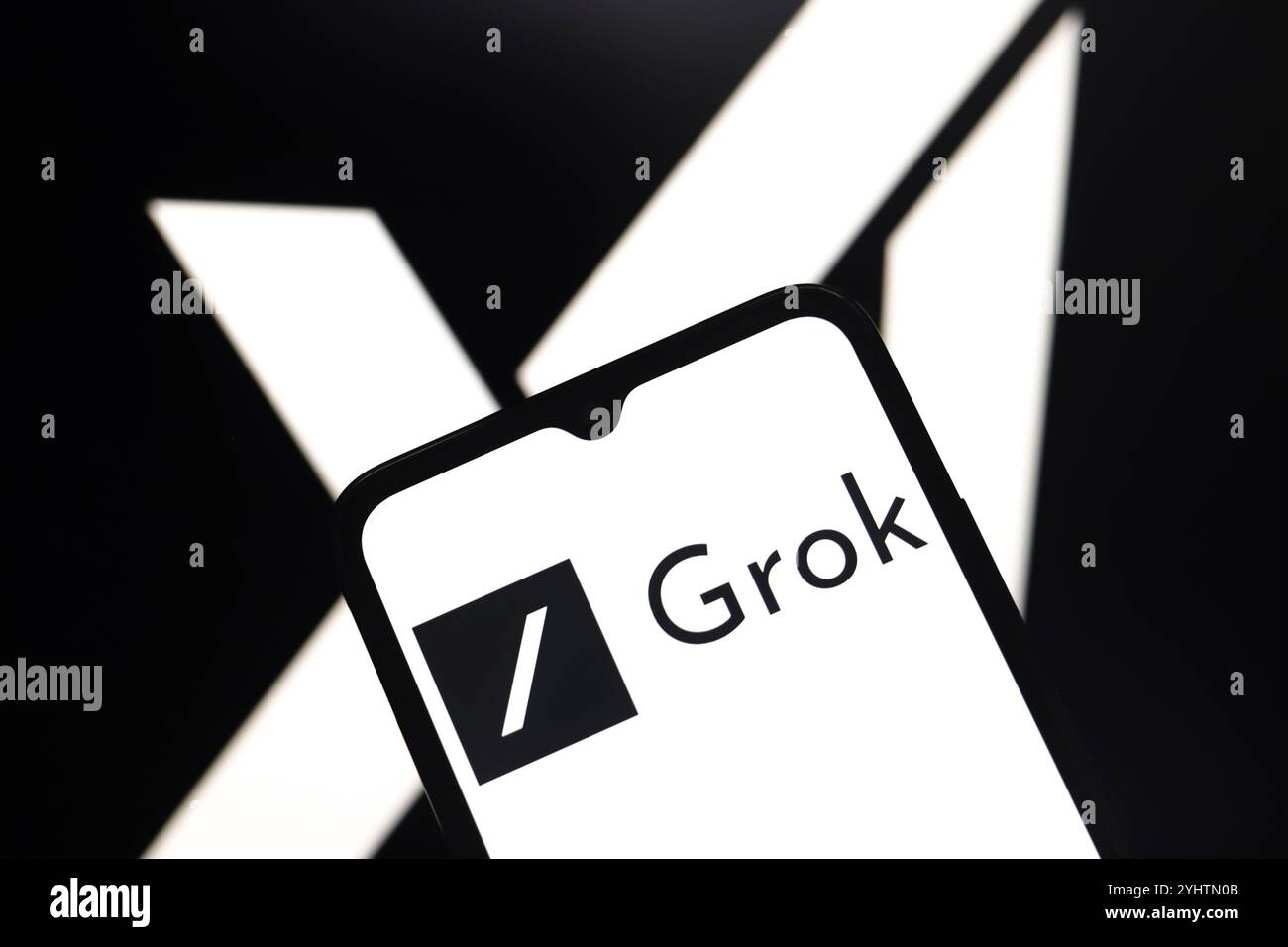 Das Grok-Logo wird auf dem Bildschirm eines Smartphones und im Hintergrund angezeigt, das XAI-Logo auf dem Computerbildschirm in Reno, USA, am Novemb Stockfoto