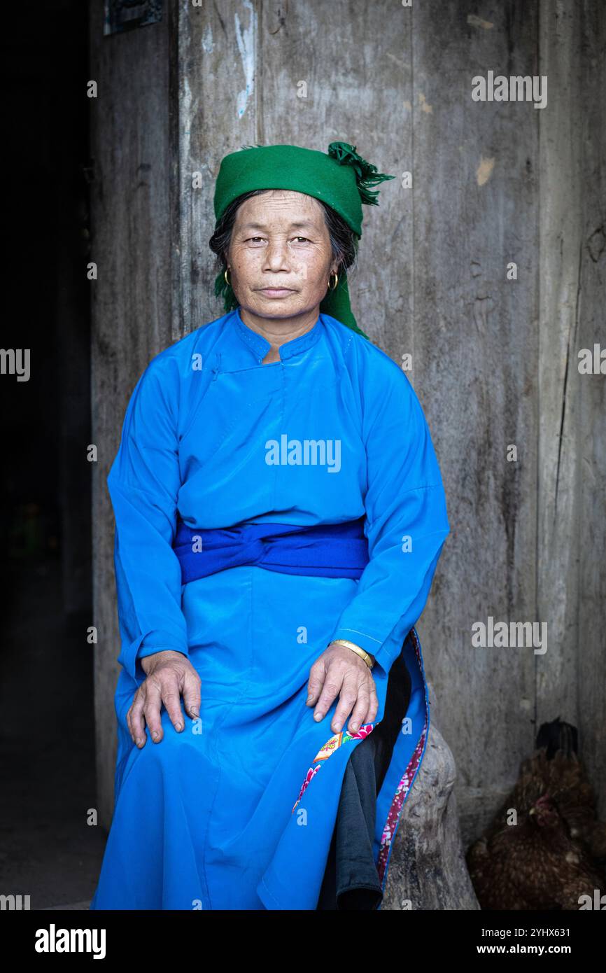 Hmong-Frau, die vor ihrem Haus in der Nähe von Dong Van in der Provinz Ha Giang in Vietnam sitzt Stockfoto