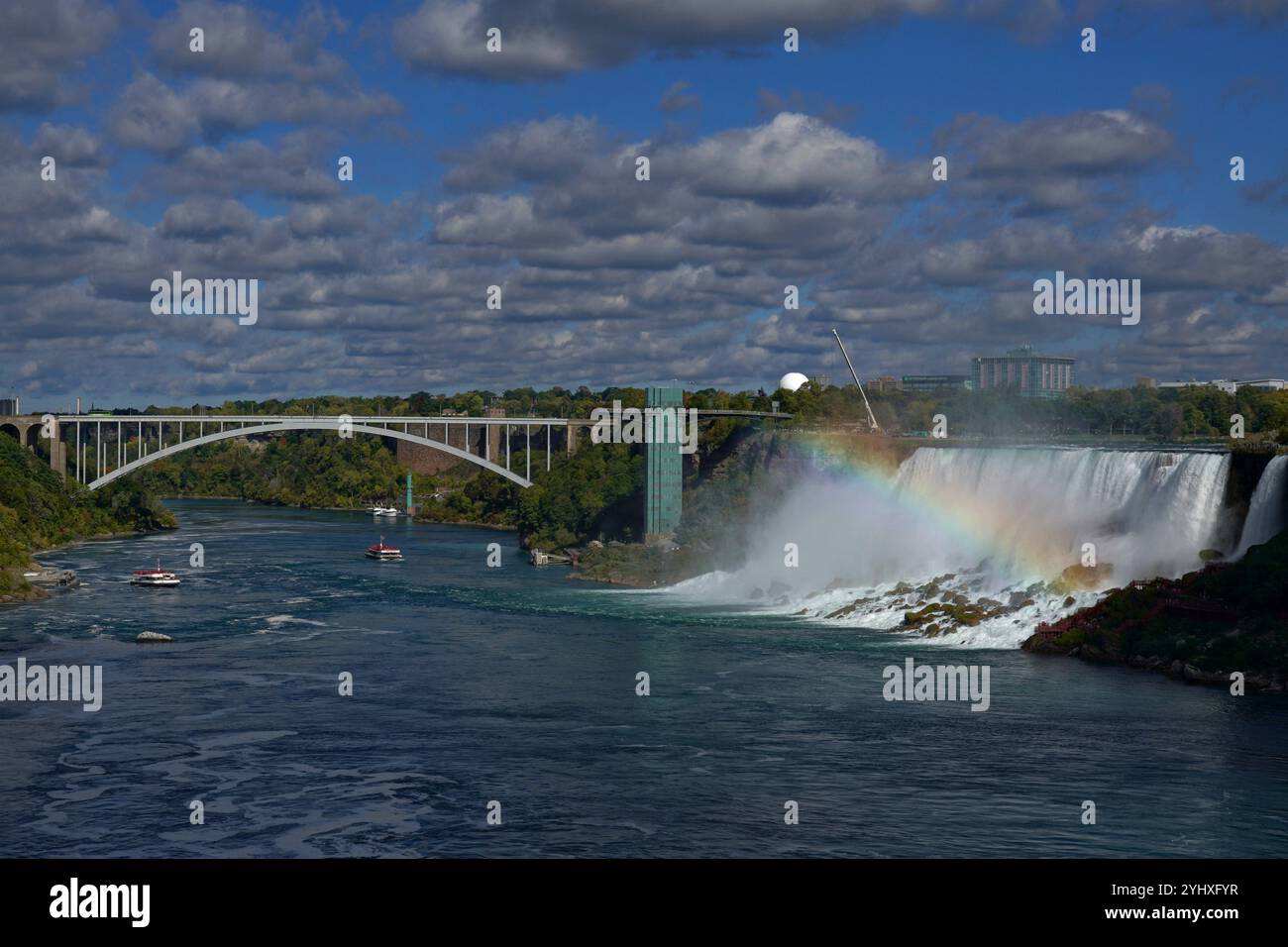 Regenbogen im Nebel der American Falls an den Niagarafällen mit Booten auf dem Fluss Stockfoto