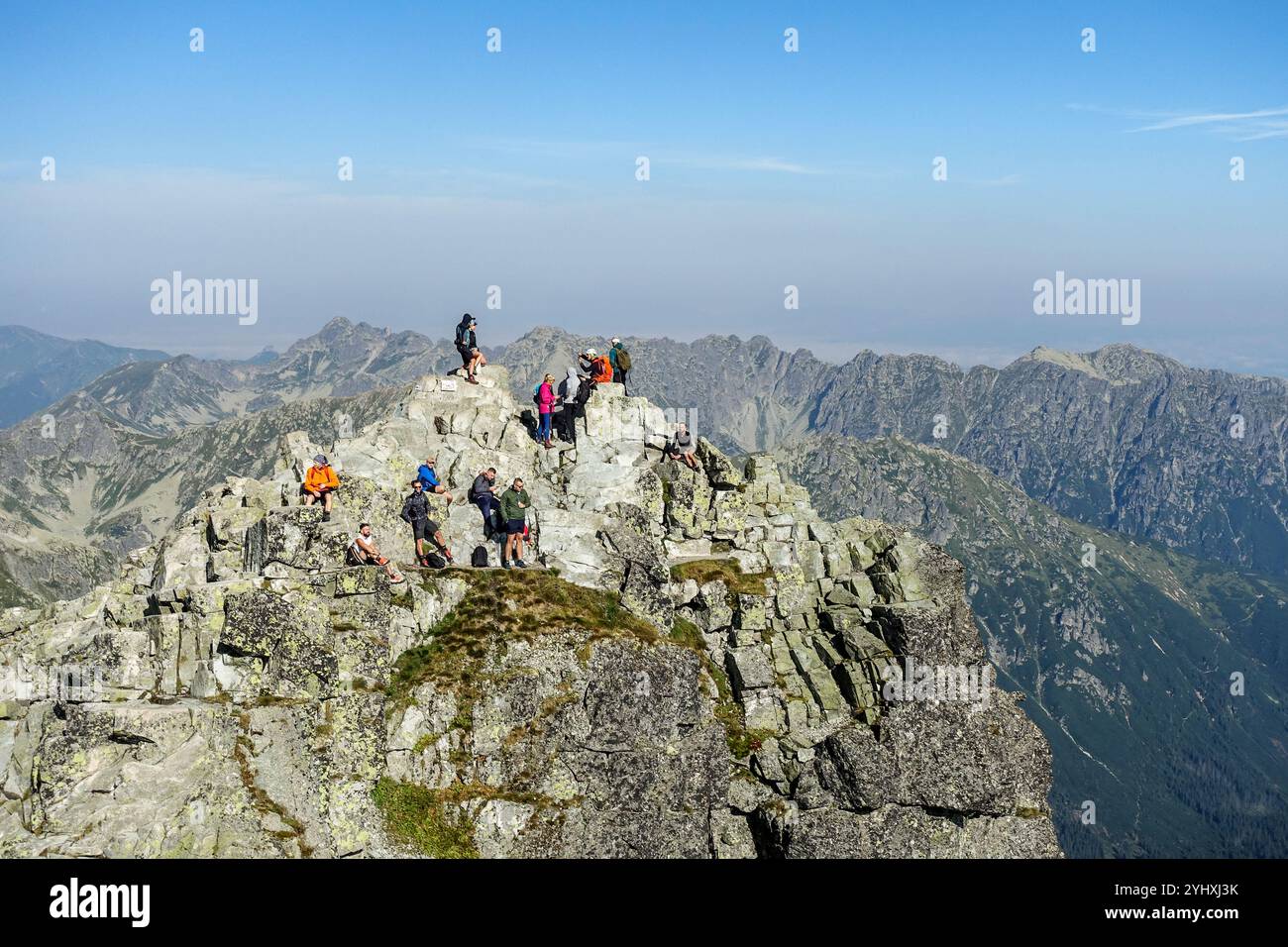 Gruppe von Wanderern, die den Panoramablick vom felsigen Gipfel eines Mount Rysy (2501 m), dem höchsten Gipfel der Slowakei und den Gipfeln der Tatra, genießen Stockfoto