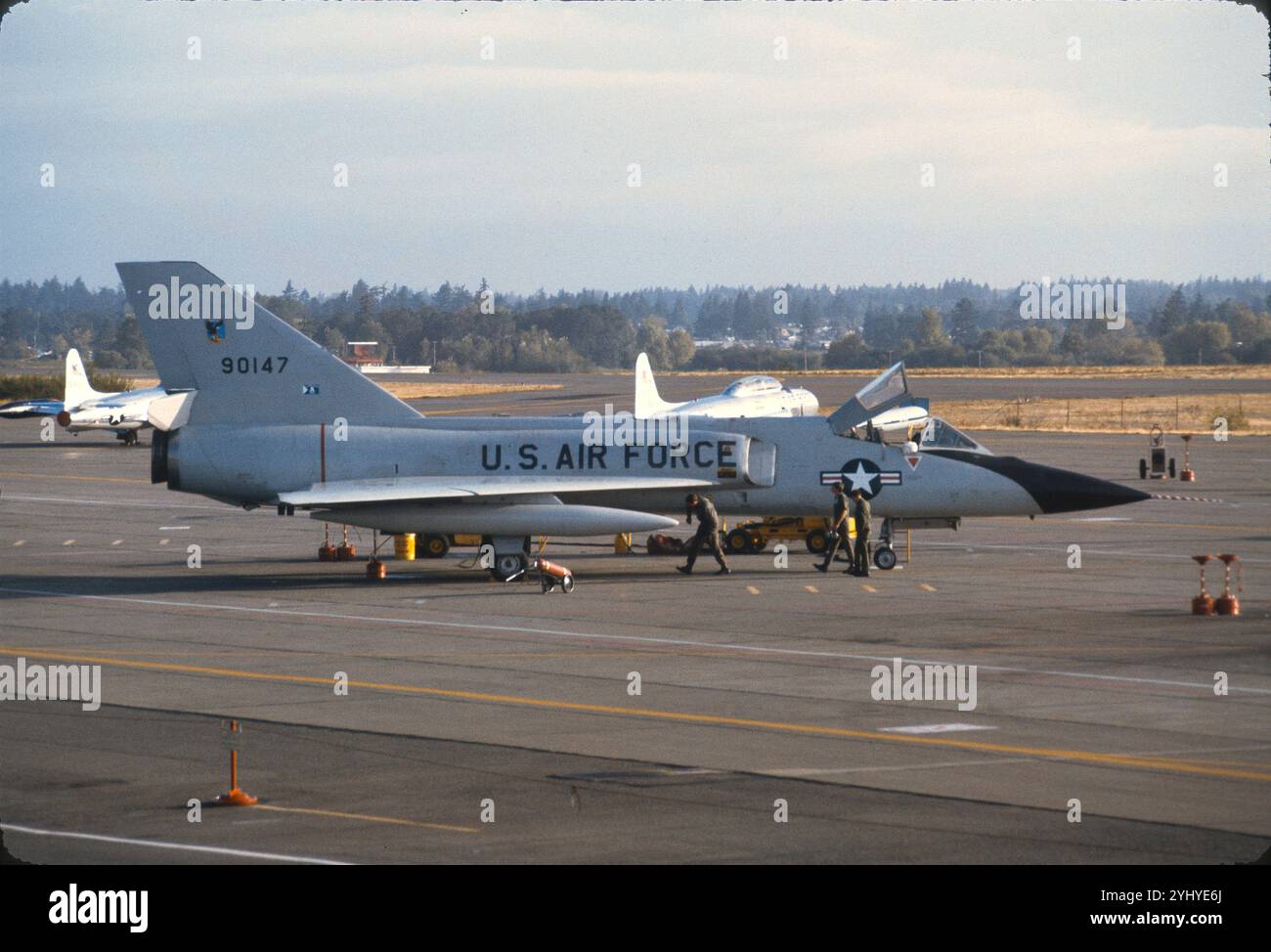 McChord AFB, 318 FIS. F-106A Heck Nr. 90147 auf Rampe während der Vorflugkontrolle. Zwei verdeckte T-33 im Hintergrund, die als Ziele für Ausbildungsmissionen dienen. Stockfoto