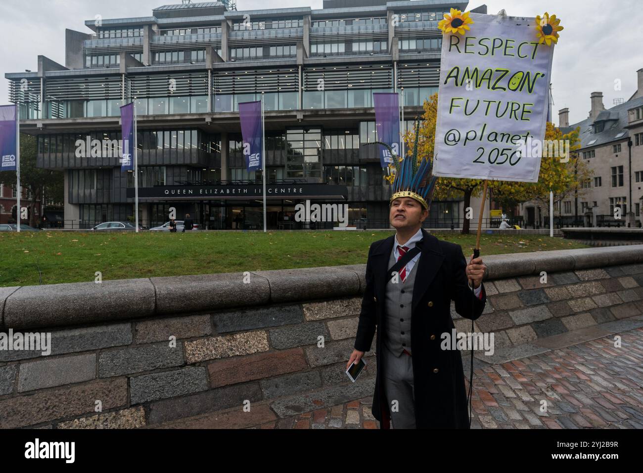 London, Großbritannien. Oktober 2017. Ein Demonstrant aus Kolumbien trägt einen traditionellen Kopfschmuck vor dem QEII-Zentrum in Westminster, wo die Hauptversammlung des globalen Bergbauriesen von BHP stattfindet. Zu den Demonstranten gehörten Vertreter der Gemeinden aus Arizona, USA, Cerrejon, Kolumbien und Minas Gerais, Brasilien, die gegen die Bergbauaktivitäten von BHP waren, die soziale und ökologische Zerstörung in ihren Gebieten verursachen. Die Katastrophe am Samarco-Staudamm in Brasilien hat riesige Gebiete verschmutzt, 25 Gemeinden werden gewaltsam vertrieben, um BHP's riesige Expansionspläne für das Kohlefeld von Cerrejon zu ermöglichen, das ein Drittel der in Großbritannien verbrannten Kohle liefert Stockfoto