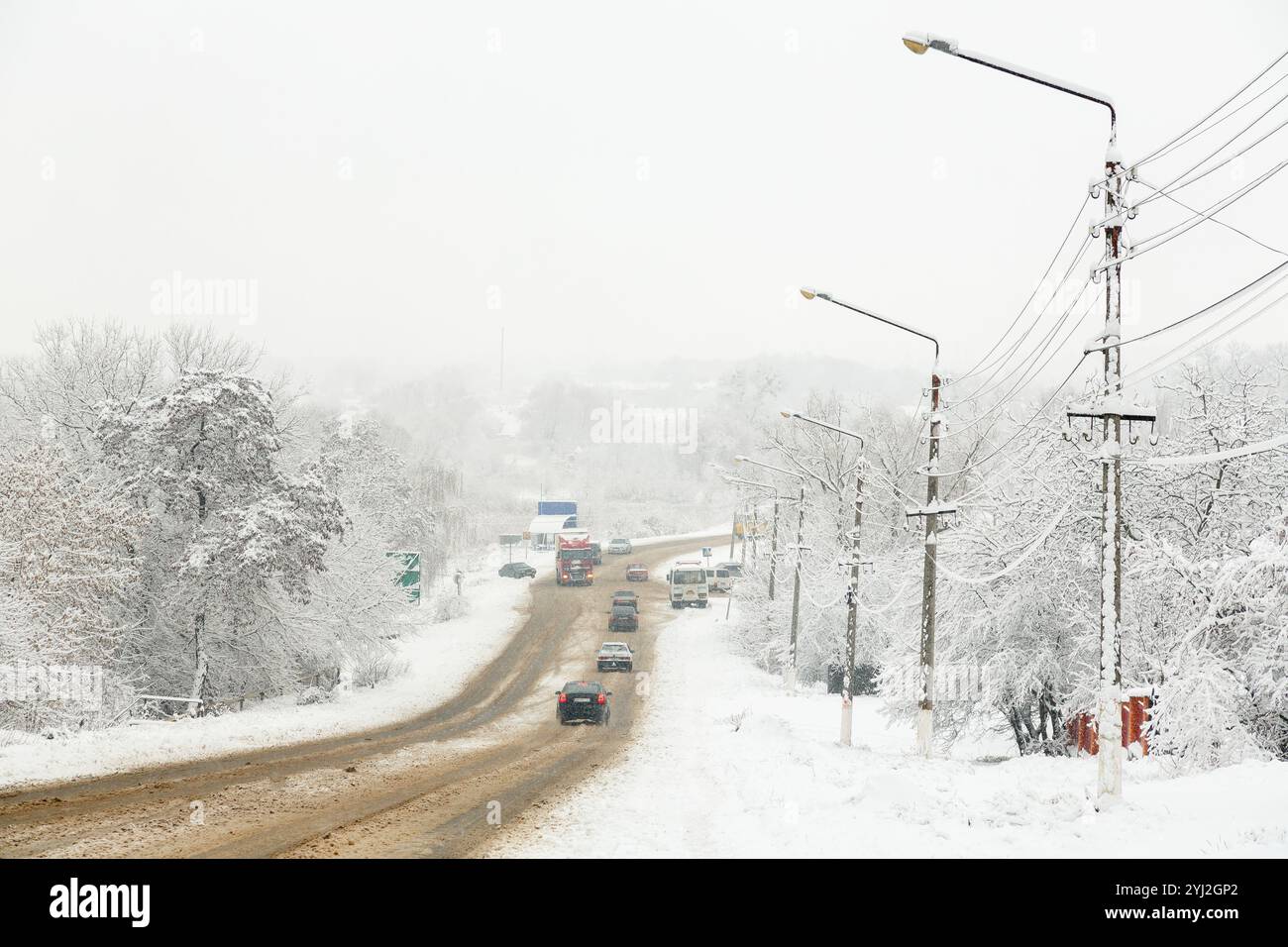 Stadtverkehr im Winter. Auf einer verschneiten Autobahn fahren Autos schnell auf einer rutschigen Straße. Gefahr von Schneefall, Schneestürmen, schlechtem Winterwetter. Ort c Stockfoto