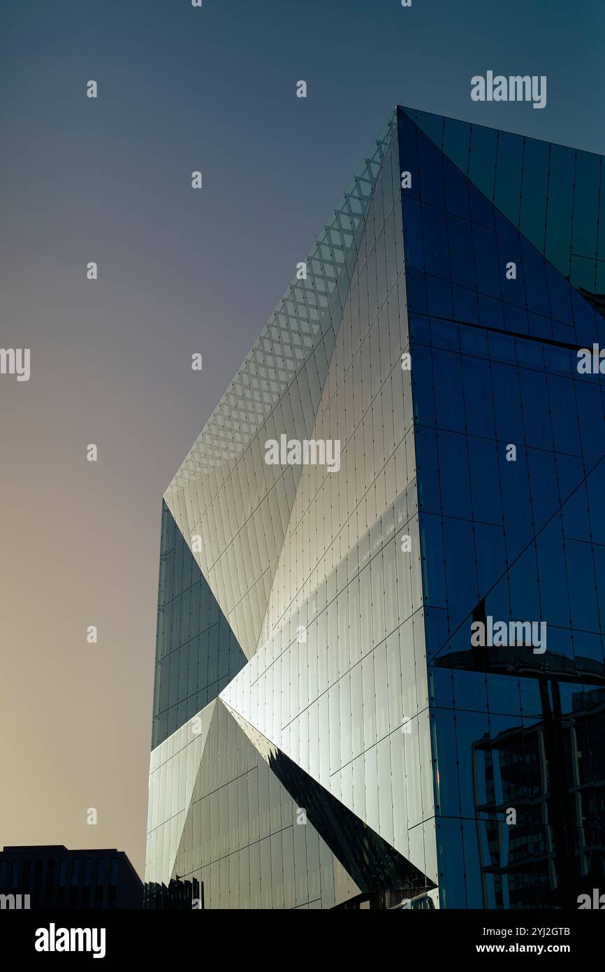Moderne Glasfassade vor klarem Himmel bei Sonnenaufgang mit kontrastierenden Schatten und Highlights, Berlin, Deutschland Stockfoto
