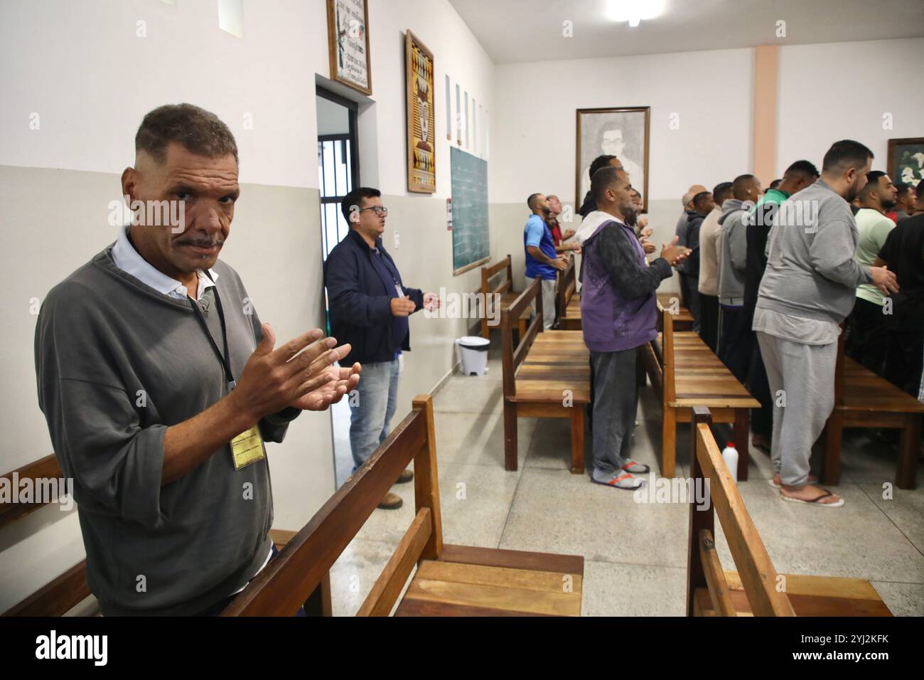 Ein Insasse klatscht mit den Händen, während er an der „Bom DIA Jesus“ teilnimmt, einer täglichen spirituellen Versammlung. In São João del-Rei im brasilianischen Bundesstaat Minas Gerais gibt ein Gefängnis ohne Waffen und Wachen, das von der Vereinigung für Schutz und Unterstützung der Sträflinge (APAC) geführt wird, eine christliche Organisation, den Häftlingen würde zurück. Die Methode zielt darauf ab, die Verantwortung der Gefangenen zu erhöhen, indem sie strenge Zeitpläne und die obligatorische religiöse Einhaltung vorschreibt. Die Erfahrung ist eine Ausnahme im brasilianischen Gefängnissystem. Stockfoto