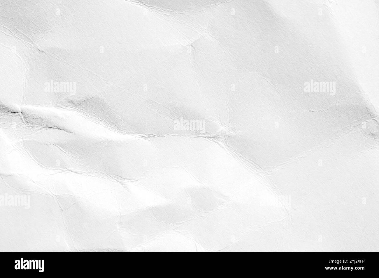 Zerknittertes weißes Papier mit subtilen Falten, das einen strukturierten abstrakten Hintergrund für minimalistische Poster und Webbanner mit roher Ästhetik schafft Stockfoto