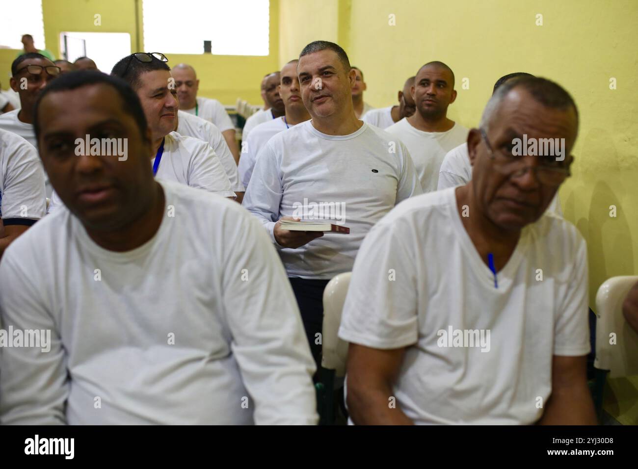 Rio De Janeiro, Brasilien. Juni 2024. Gefangene hören sich Buchpräsentationen von Mitgefangenen an. Im Untersuchungsgefängnis Evaristo de Moraes in Rio de Janeiro, Brasilien, fand ein Leserworkshop statt. In Brasilien zielt das Projekt Remission for Reading darauf ab, Gefangene zu rehabilitieren, indem sie ihnen helfen, ihre Strafen durch das Lesen von Büchern zu reduzieren. Die Behörden hoffen, dass das bei Häftlingen Leseliebhaber anregt und Rückfälle reduziert. Quelle: SOPA Images Limited/Alamy Live News Stockfoto