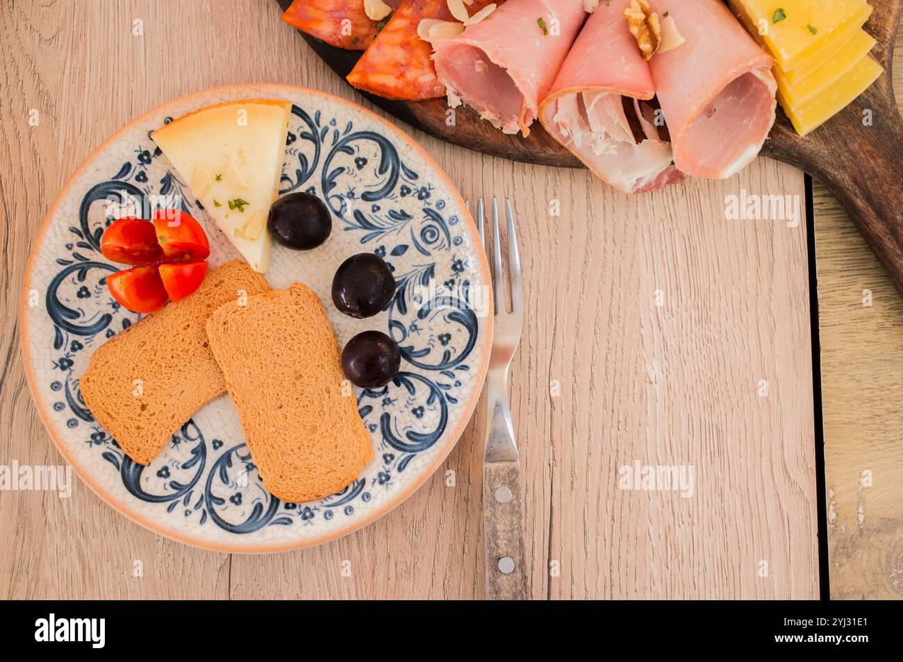 Portugiesische Wurstplatte mit Schinken, verschiedenen Käsesorten und Brot, direkt darüber Stockfoto