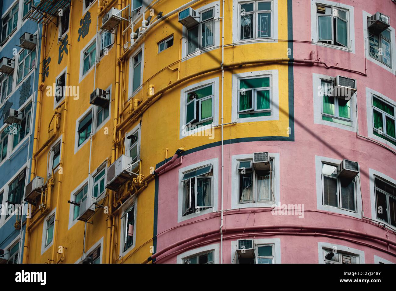 Eine einzigartige, abgerundete Struktur mit hellen Farben hebt sich deutlich von der städtischen Landschaft Hongkongs ab. Stockfoto