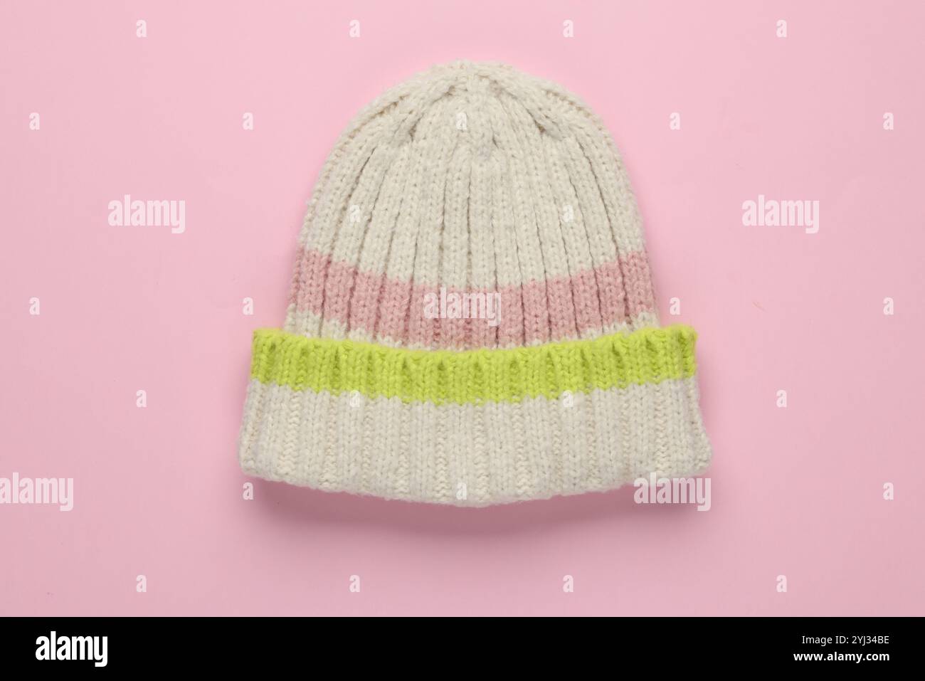 Warmer Wollmütze auf hellrosa Hintergrund, Draufsicht Stockfoto