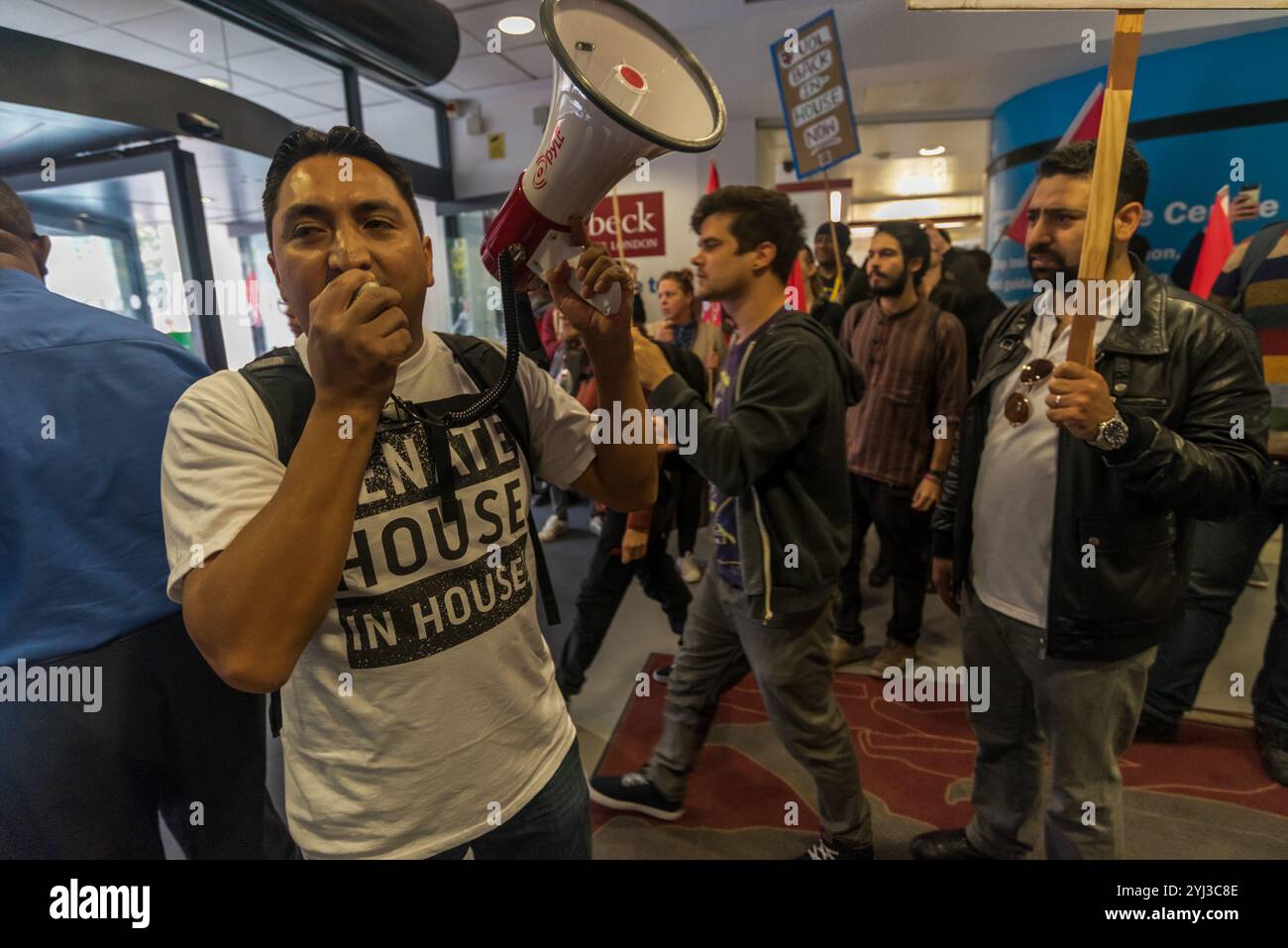 London, Großbritannien. September 2017. Ein Sicherheitsmann sagt, dass die Demonstranten die Lobby des Birkbeck College verlassen müssen, wo sie einen lauten Protest abhalten. Zu den Arbeitnehmern gehören Sicherheitspersonal, das seit 2011 nicht die versprochenen Gehaltserhöhungen erhalten hat, um die Unterschiede aufrechtzuerhalten. Der laute Protest an der Universität mit anderen prekären Arbeitern kam nach einem Marsch von einem frühen Morgen "Ende prekärer Arbeit!" An dem Tag, an dem Uber gegen die Entscheidung, dass ihre Fahrer Arbeiter sind, Berufung eingelegt hat Stockfoto