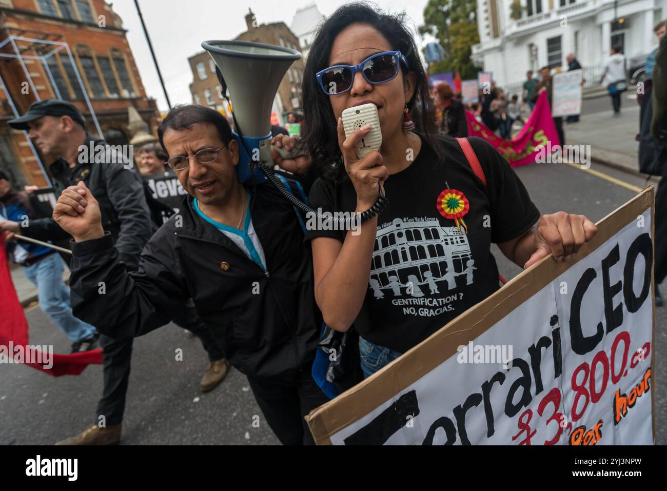 London, Großbritannien. 30. September 2017. Demonstranten tanzen vor dem Ferrari-Showroom des Kensington-Luxuswagenhändlers HR Owen bei den United Voices of the World Trade union Protest, dass sie ihre beiden Putzfrauen wieder einsetzen, die ohne Bezahlung ausgesetzt wurden, weil sie darum baten, für die Reinigung der Ferrari/Maserati Showrooms einen Lebenshaltungslohn in London zu erhalten. Die Putzer Angelica Valencia und Freddy Lopez wurden von der UVW und anderen Gruppen wie Class war und der RCG unterstützt. Etwa hundert Demonstranten marschierten von der South Kensington Station aus und protestierten kurz vor den Lamborghini Showrooms und dem Büro Stockfoto