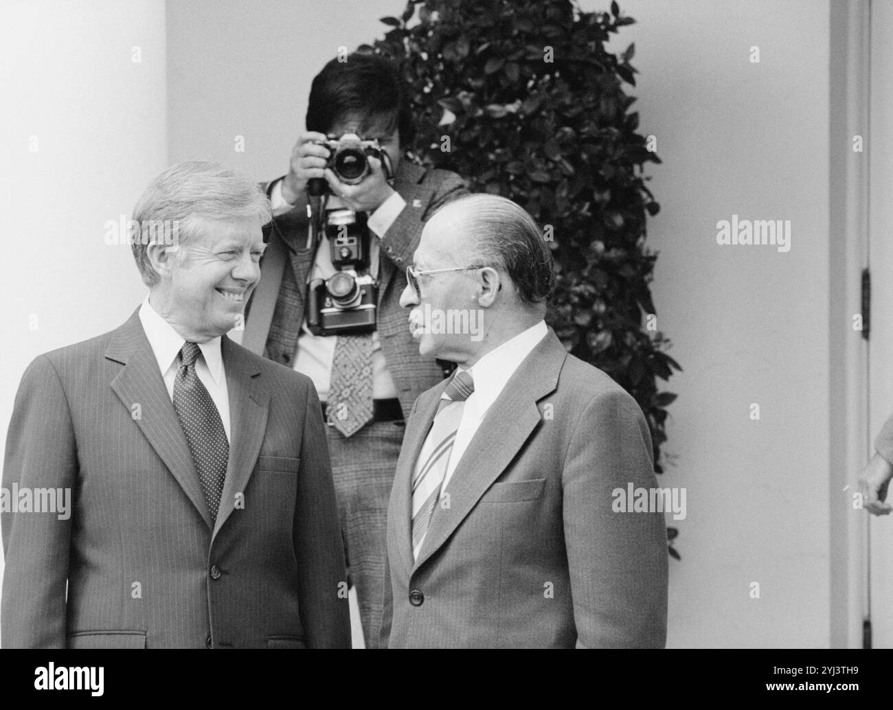 Präsident Jimmy Carter und der israelische Premierminister Menachem beginnen im Weißen Haus, Washington, D.C., als ein Fotograf seine Kamera im Hintergrund justiert. USA. 15. April 1980 Stockfoto