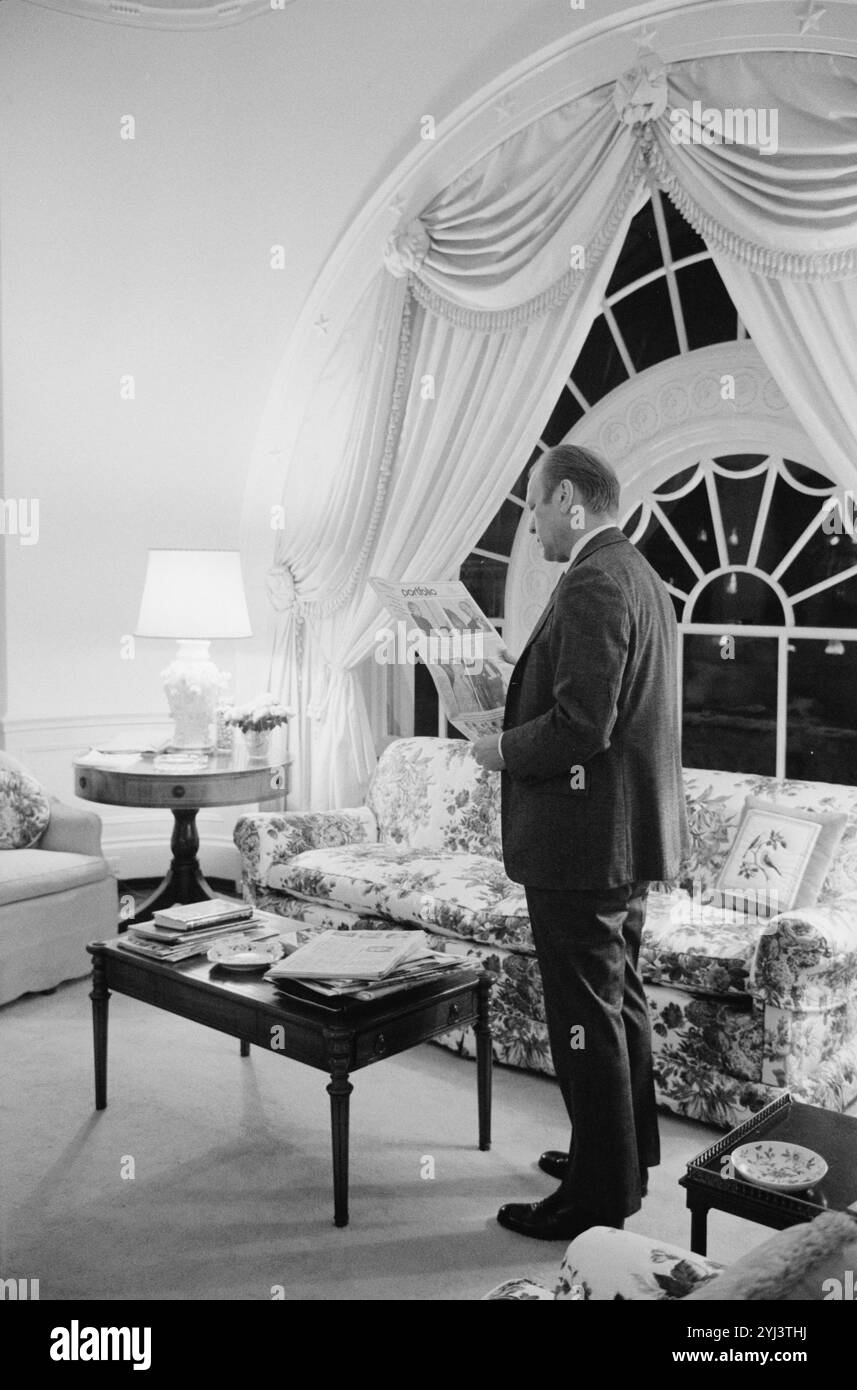 Präsident Gerald Ford liest die Zeitung in den Wohnräumen des Weißen Hauses in Washington, D.C., USA. 6. Februar 1975 Stockfoto