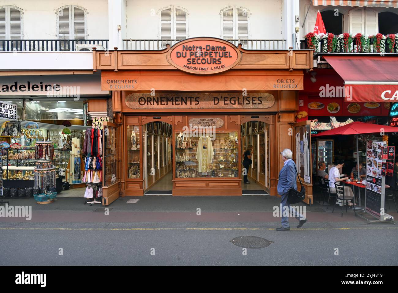 Man läuft an einem religiösen Kleiderladen, einem Kirchenladen oder einem christlichen Souvenirladen in Lourdes Hautes-Pyrénées Frankreich vorbei Stockfoto