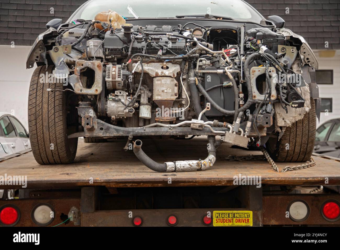Detroit, Michigan - Ein kaputtes Auto auf einem Tieflader mit einem Aufkleber auf dem steht: Student Driver. Stockfoto