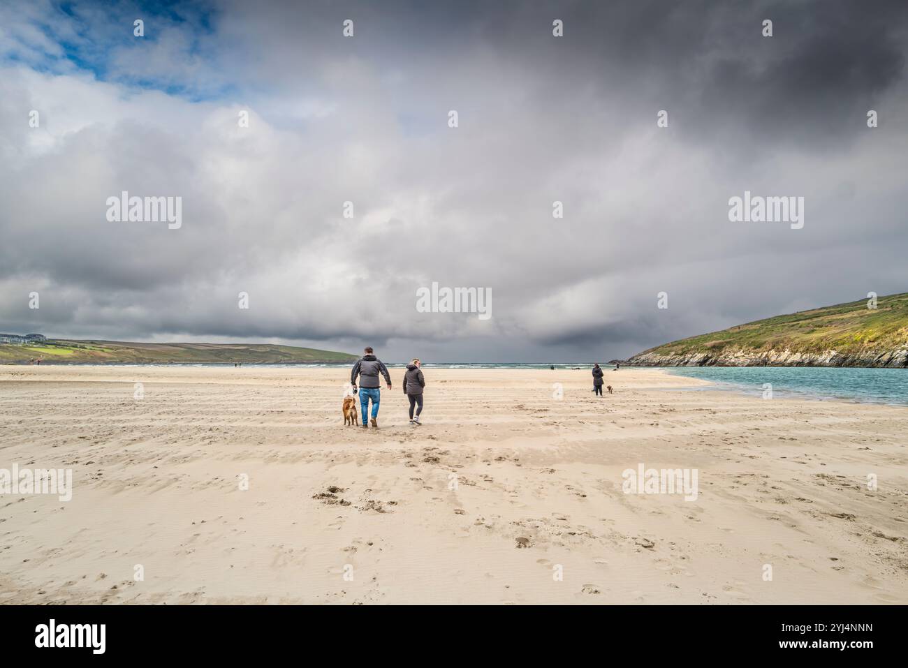 Menschen gehen bei Ebbe am Crantock Beach in Newquay in Cornwall, Großbritannien. Stockfoto