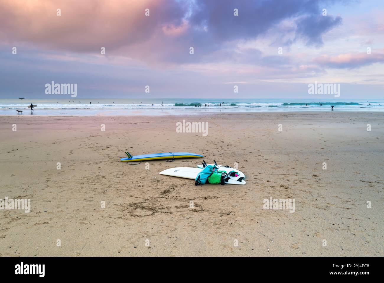 Pastellfarbener Himmel über Ebbe mit Surfbrettern und Taschen am GT Western Beach an der Küste von Newquay in Cornwall in Großbritannien. Stockfoto
