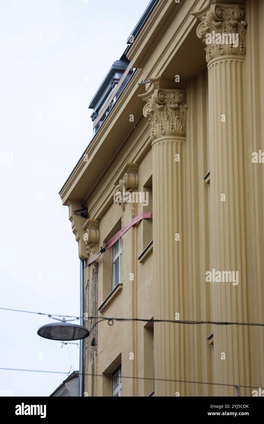 Im strengen Zentrum von Zagreb, in der Masarykova-Straße, ist der Anblick einer von Balken gehaltenen, gerissenen Giebelwand und einer Holzkonstruktion zu einem Symbol für die langfristigen Probleme des Wiederaufbaus nach dem Erdbeben vom März 2020 geworden. Das Gebäude, in dem Unternehmer und ein bekannter Politiker angeblich Wohnungen haben, muss dringend renoviert werden. Dennoch bleibt die Situation aufgrund von Meinungsverschiedenheiten zwischen den Stadtkonservatoren und Statikexperten unverändert, was weitere Schritte bei der Restaurierung verhindert. Die Leute passieren diesen unsicheren Teil des Gebäudes, der die Passage des Bak bildet Stockfoto