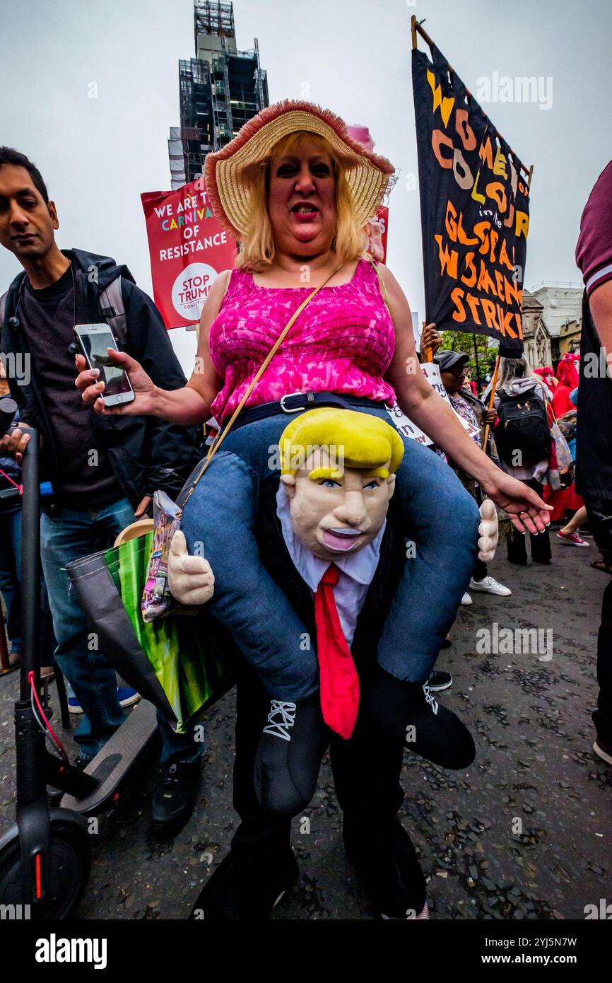 London, Großbritannien. Eine Frau in einem Kostüm, das sie von Trump tragen lässt, kommt auf dem Parlamentsplatz zur weiteren Kundgebung an, um eine klare Botschaft zu senden, dass Präsident Trump hier wegen seiner Klimaverleugnung, seines Rassismus, seiner Islamophobie, seiner Frauenfeindlichkeit und seiner Bigotterie nicht willkommen ist. Seine Politik des Hasses und der Spaltung hat die extreme Rechte auf der ganzen Welt mit Energie versorgt. Stockfoto