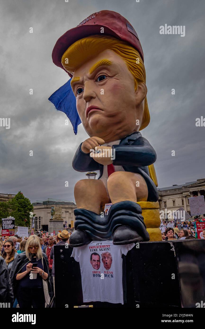 London, Großbritannien. Ein riesiges Modell Trump sitzt auf einer Toilette und twittert auf dem Trafalgar Square, wo Tausende kamen, um eine klare Botschaft zu senden, dass Präsident Trump hier nicht willkommen ist wegen seiner Klimaverleugnung, seines Rassismus, seiner Islamophobie, seiner Frauenfeindlichkeit und seiner Bigotterie. Seine Politik des Hasses und der Spaltung hat die extreme Rechte auf der ganzen Welt mit Energie versorgt. Sie marschierten zu einer Kundgebung in Whitehall, in der Nähe des Treffens mit Theresa May mit Reden von Jeremy Corbyn, Caroline Lucas und anderen führenden Politikern und Aktivisten, und dann zu einer weiteren Kundgebung auf dem Parliament Square. Stockfoto