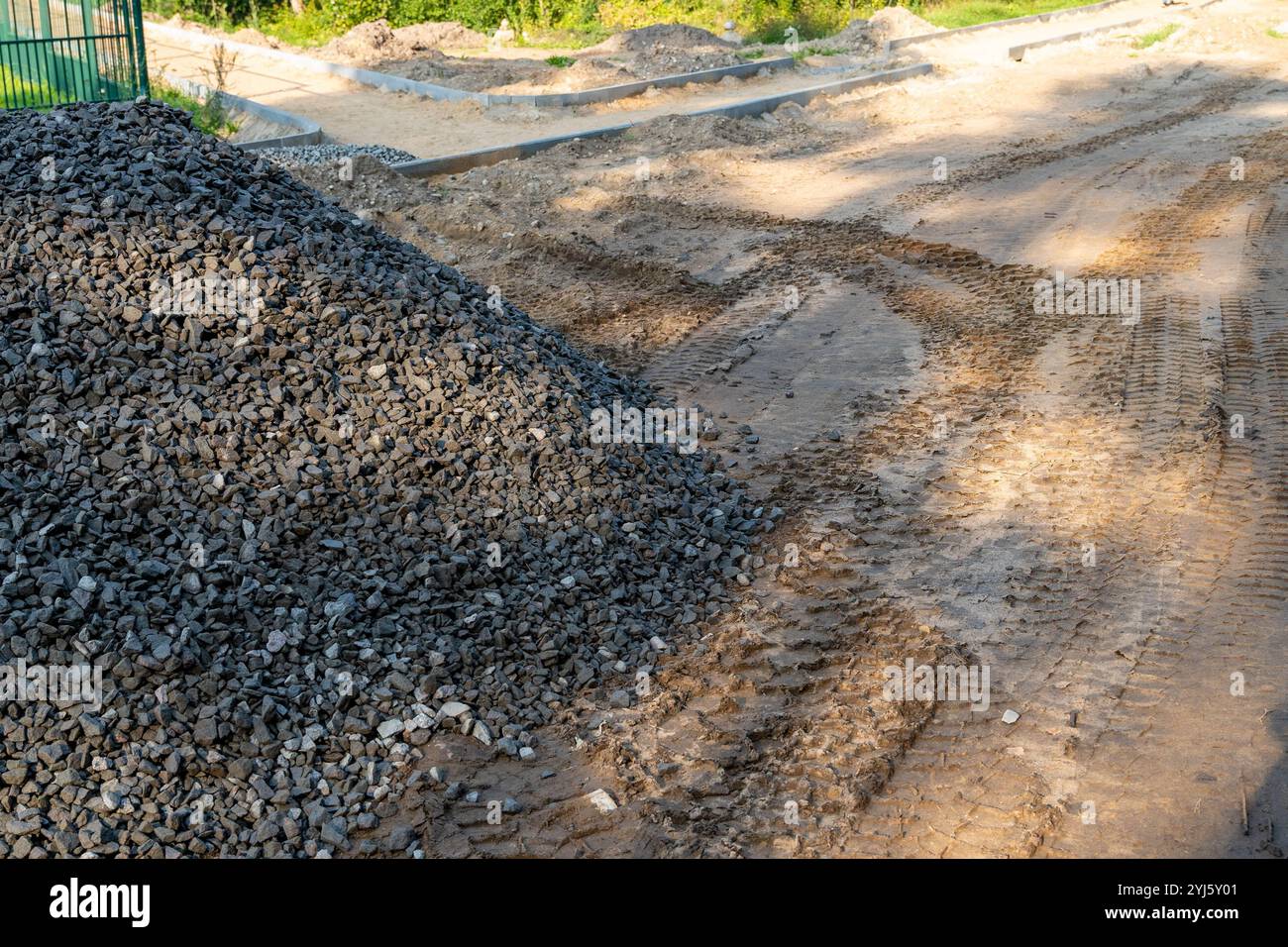 Ein großer Schotterhaufen befindet sich neben einer frisch gestörten Schotterstraße. Stockfoto