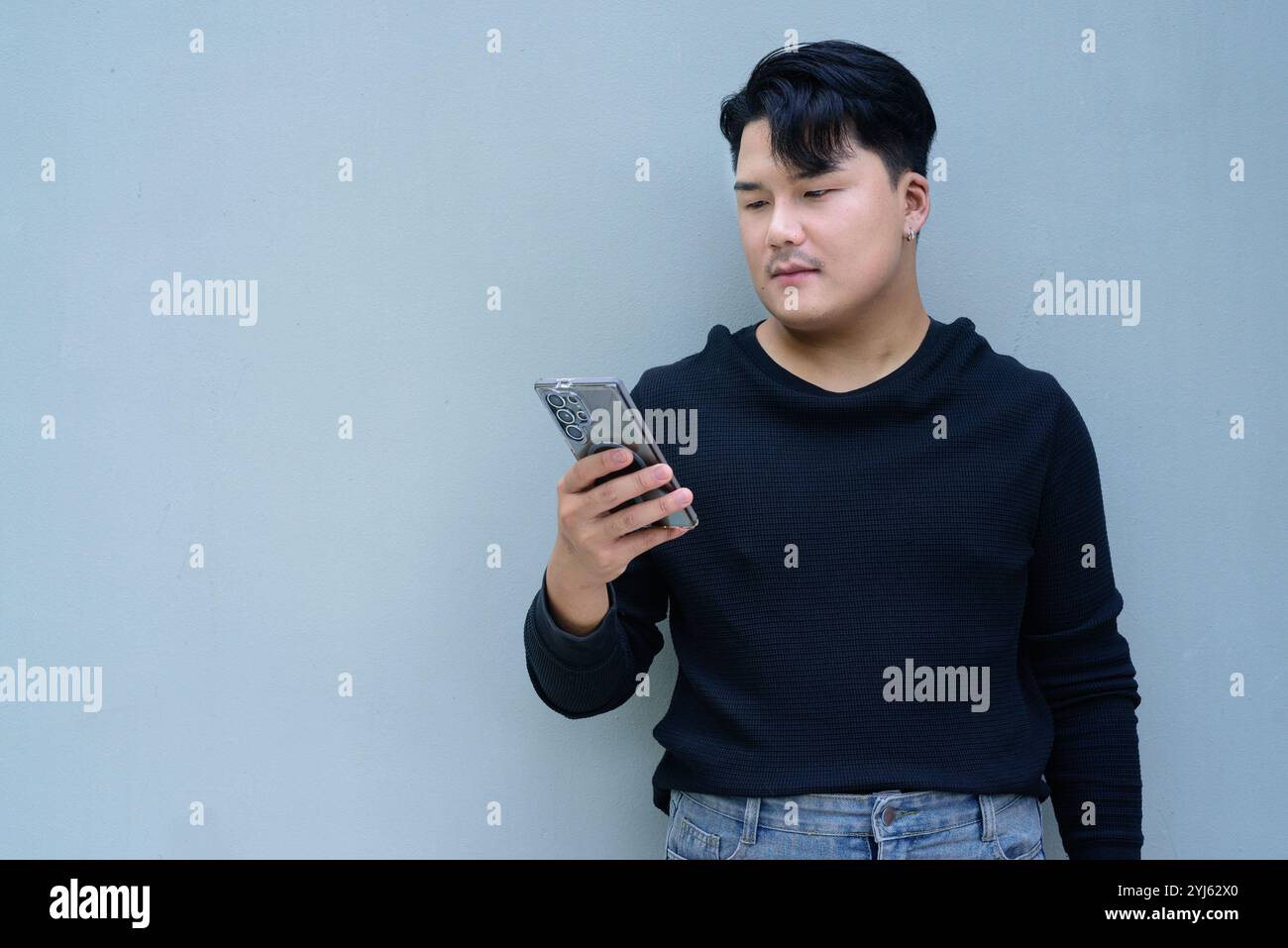 Porträt eines hübschen jungen asiatischen Mannes gegen das Konzept des freien Hintergrunds Stockfoto