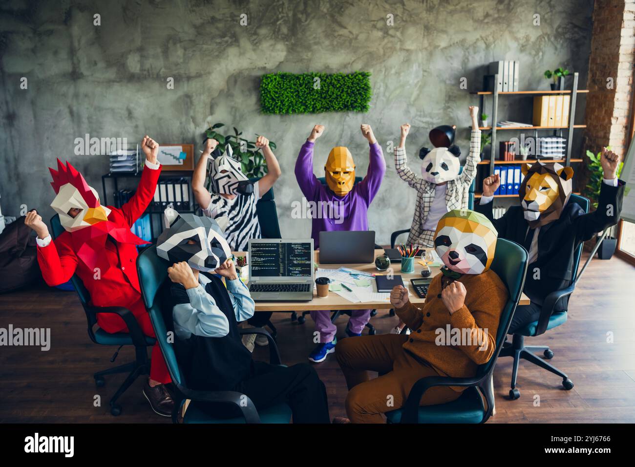 Porträt von Panda Hahn Gorilla Löwe Faultier Zebra Waschbär Maske Leute treffen Raise Fäuste Loft Business Center innen Stockfoto