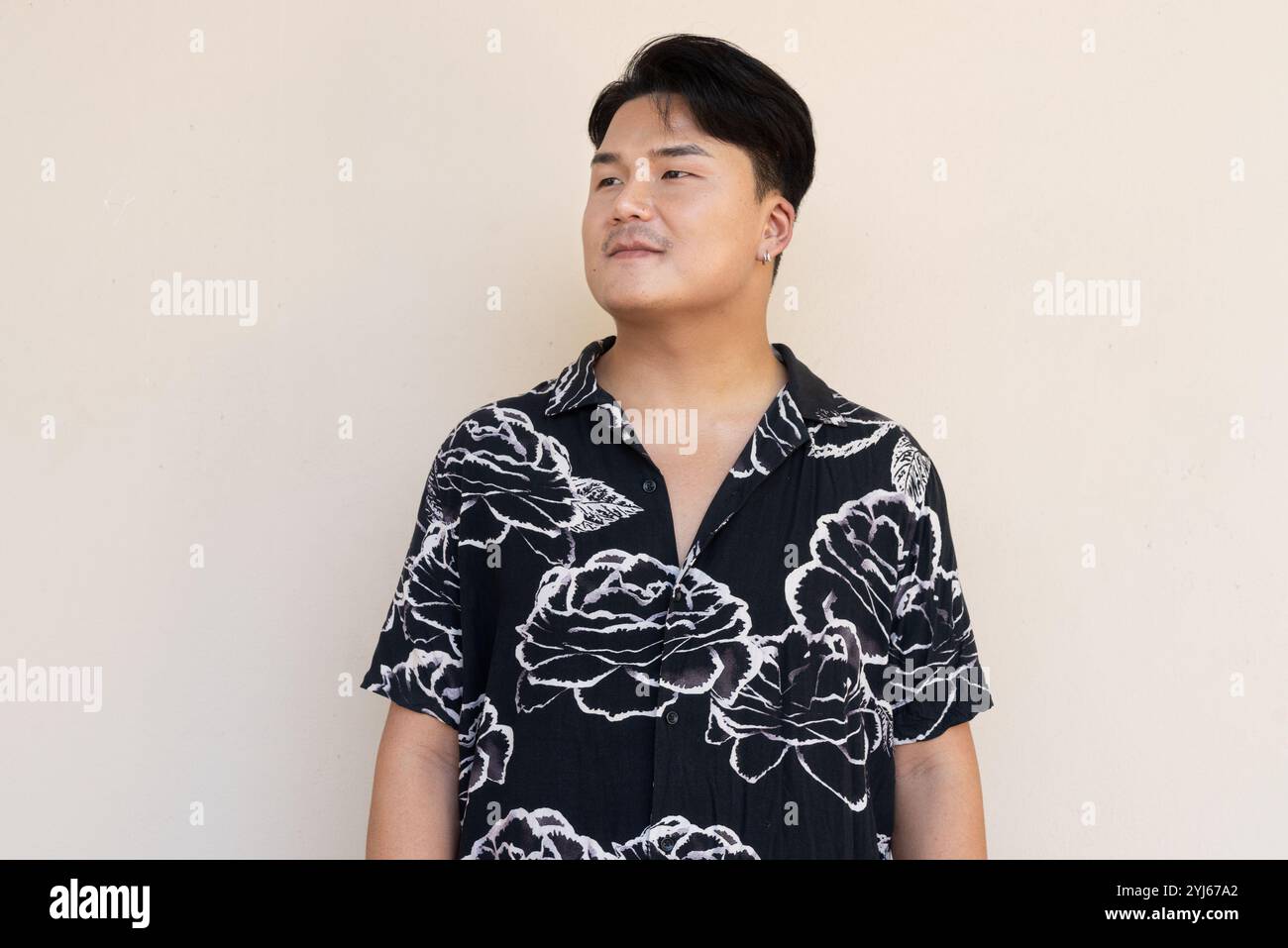 Porträt eines gutaussehenden jungen asiatischen Mannes gegen das Konzept des Plain Background Stockfoto