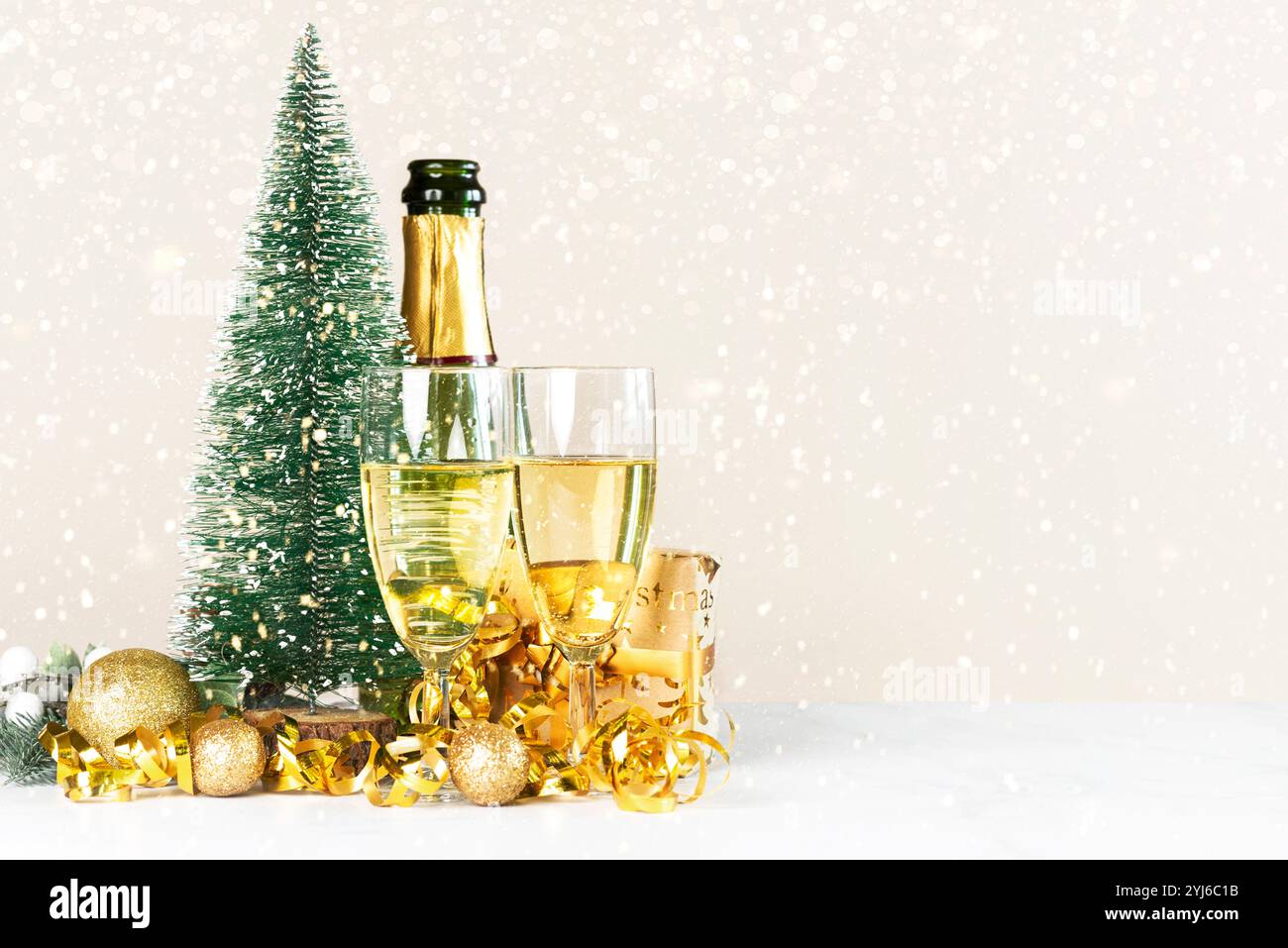 Flasche Champagner mit Kristallgläsern, goldenen weihnachtskugeln, weihnachtsbaum und Platz für Text auf weihnachtlichem Hintergrund. Silvesterfeier Stockfoto