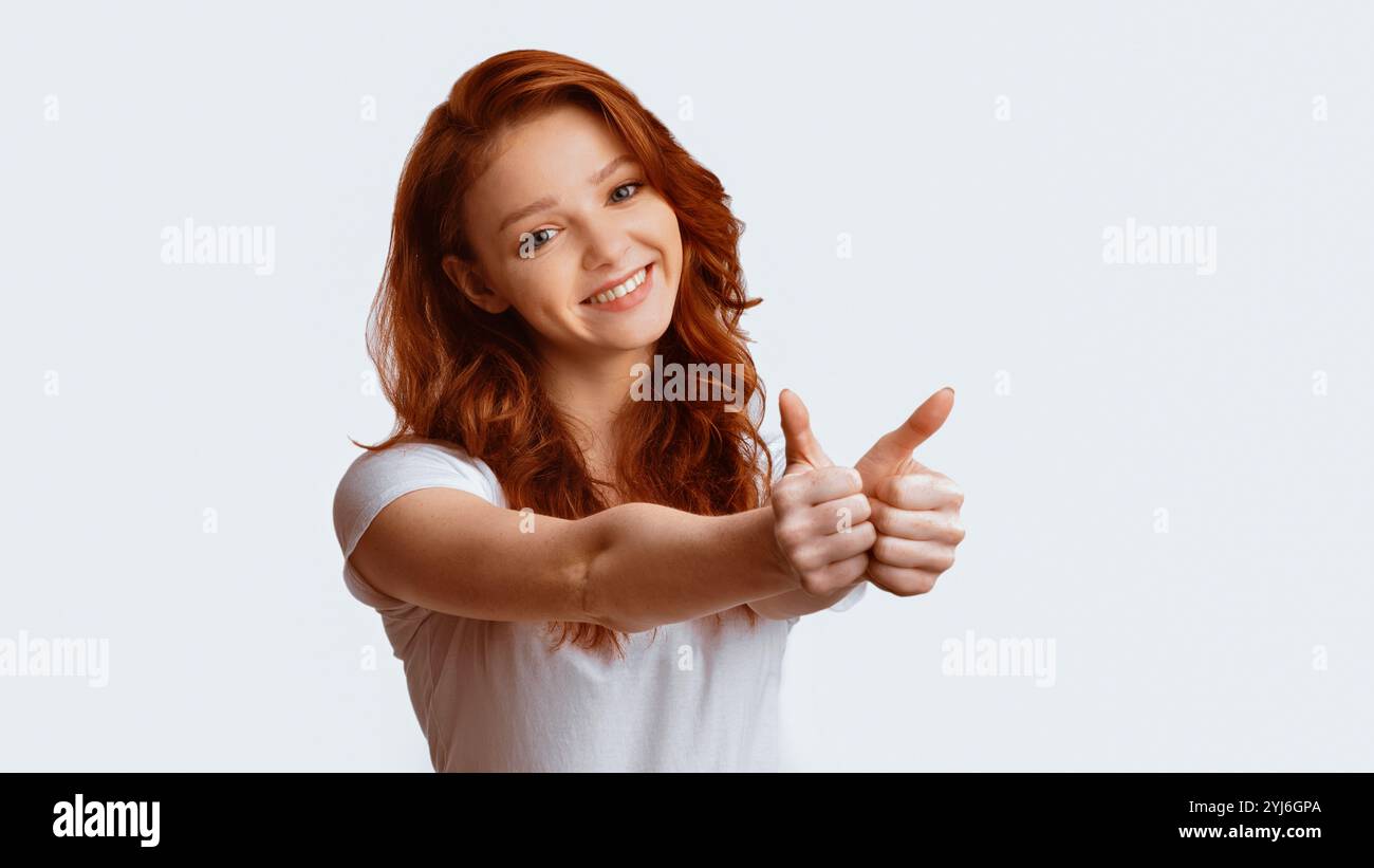 Ich mag es. Schönes Teenager-Mädchen, Das Daumen Nach Oben Mit Beiden Händen Posiert Über Weißem Hintergrund. Panorama, Studio-Aufnahme Stockfoto