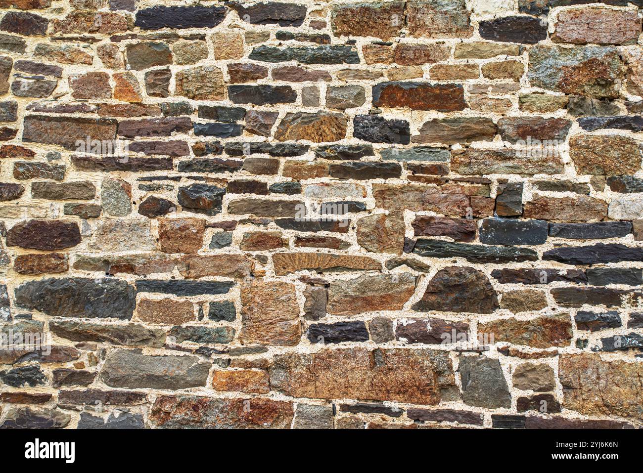Textur einer alten Steinmauer in Braun, Rot und Schwarz Stockfoto