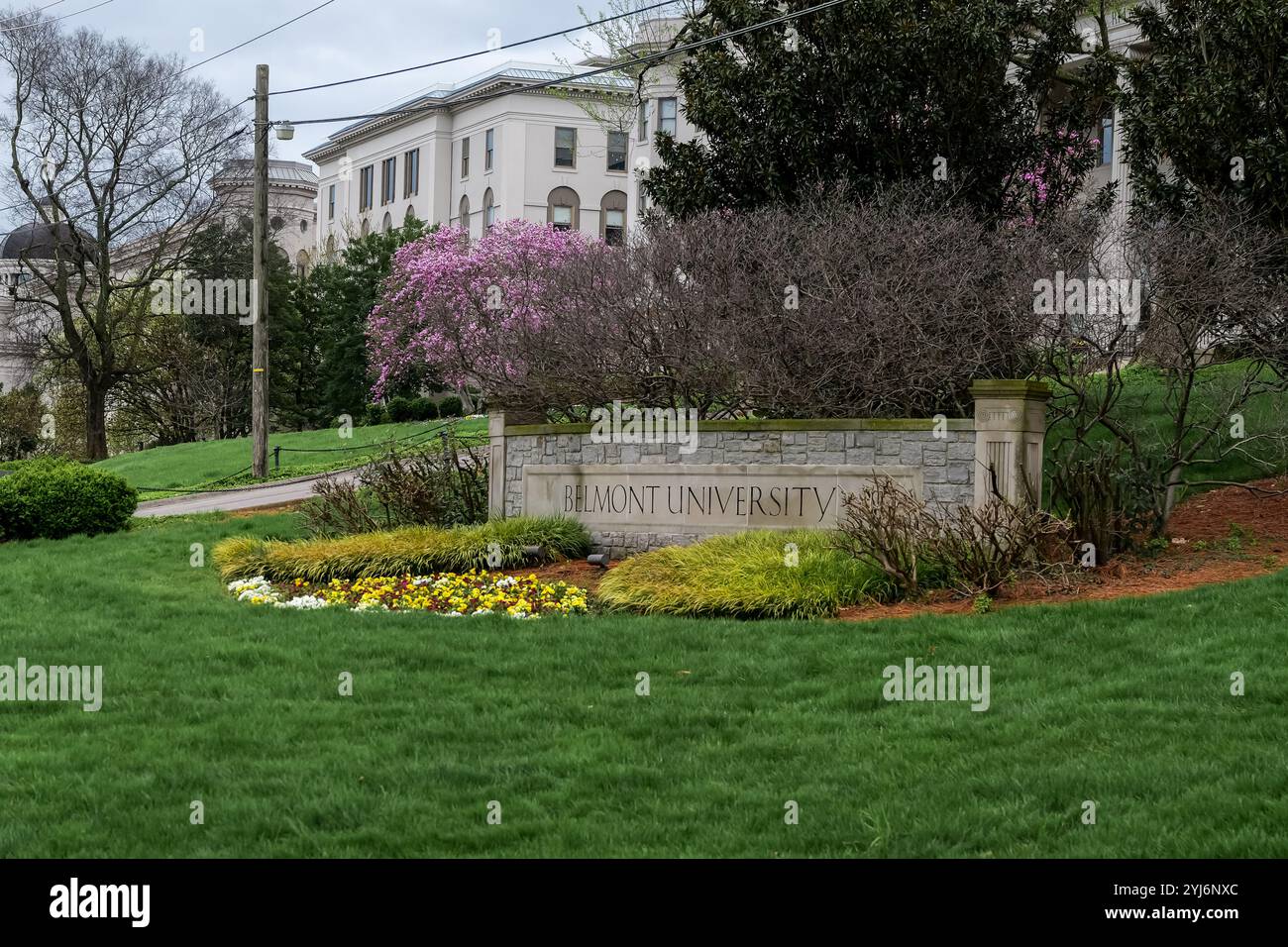 NASHVILLE, TN - 15. März 2024: Schild der Belmont University mit umliegenden Blumen und Sträuchern und grünem Rasen. Stockfoto