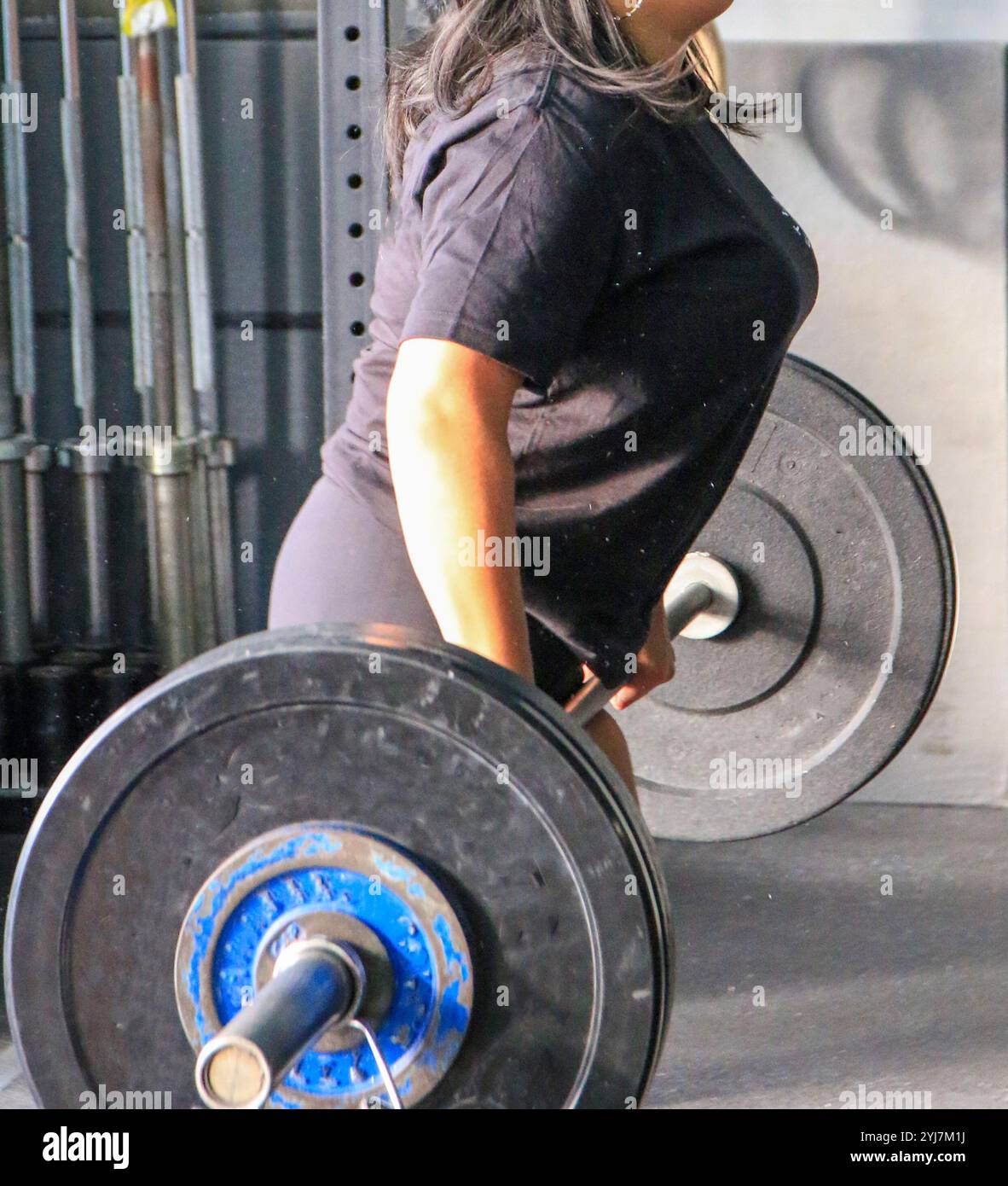 Seitenansicht einer Person führt einen Deadlift in einem Fitnessstudio durch und zeigt Kraft und Konzentration während ihrer Trainingsroutine. Stockfoto