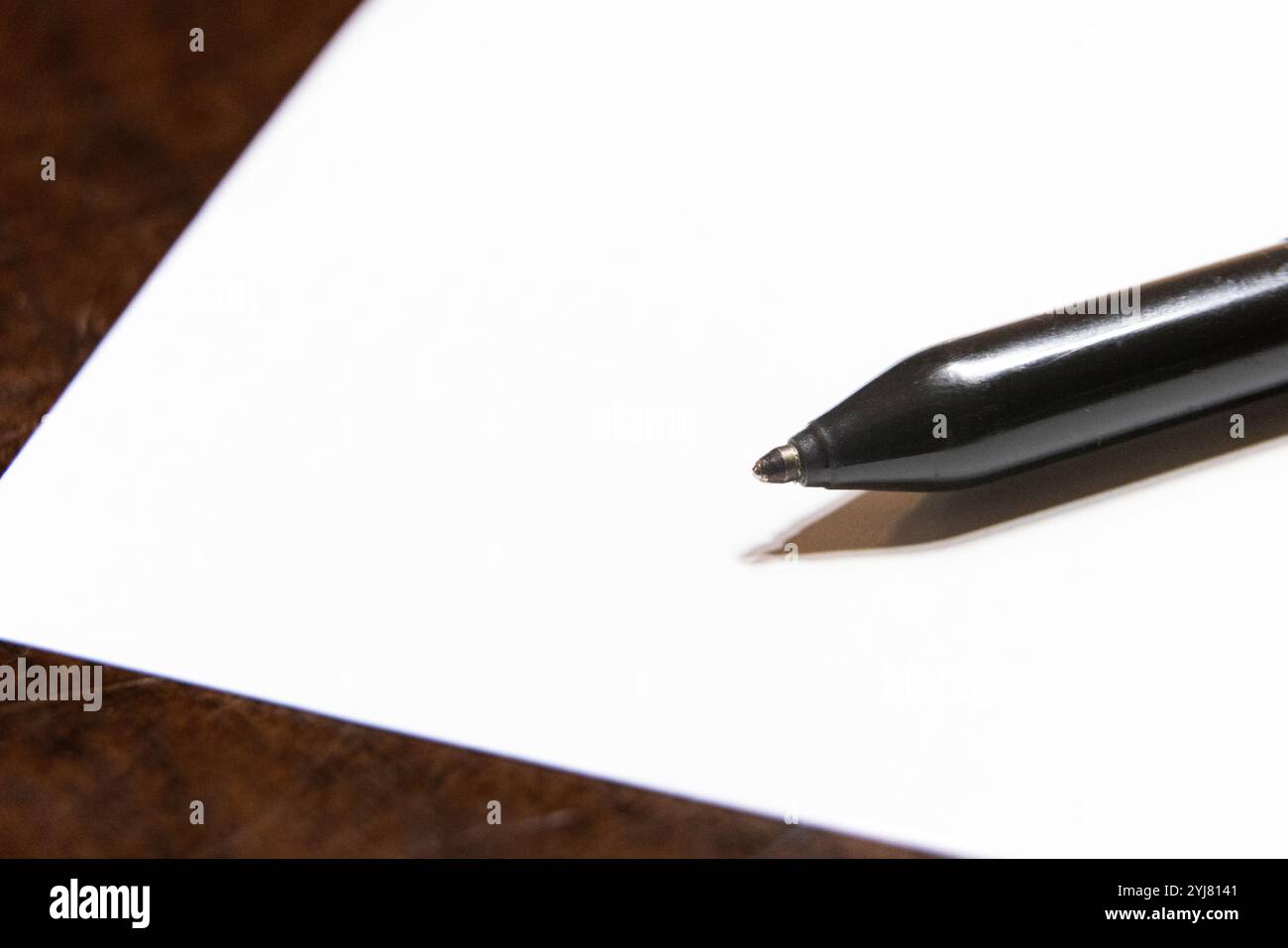Nahaufnahme eines schwarzen Kugelschreibers auf weißem Hintergrund mit Kopierraum. Vorbereitung zum Schreiben von Notizen. Denken. Leerzeichen. Stockfoto
