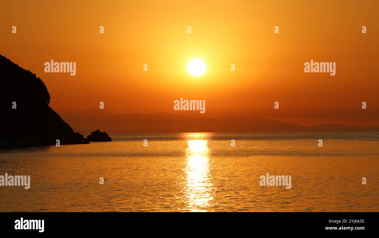 Blick auf die Meereslandschaft bei Sonnenuntergang an der Küste. Helles Sonnenlicht, das über die Meereslandschaft strahlt Stockfoto