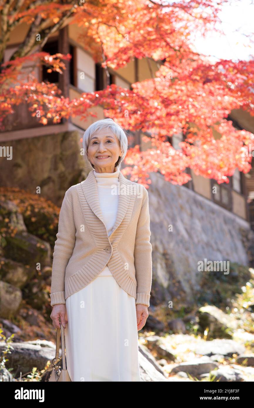 Ältere Frau genießt Herbstlaub-Peeping. Stockfoto