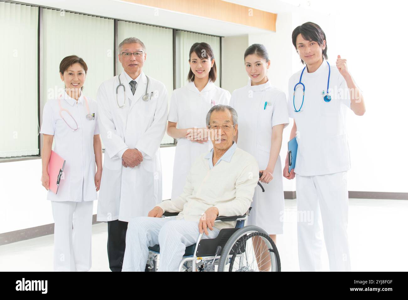 Seniorin im Rollstuhl mit Arzt und Schwesterngruppe Stockfoto