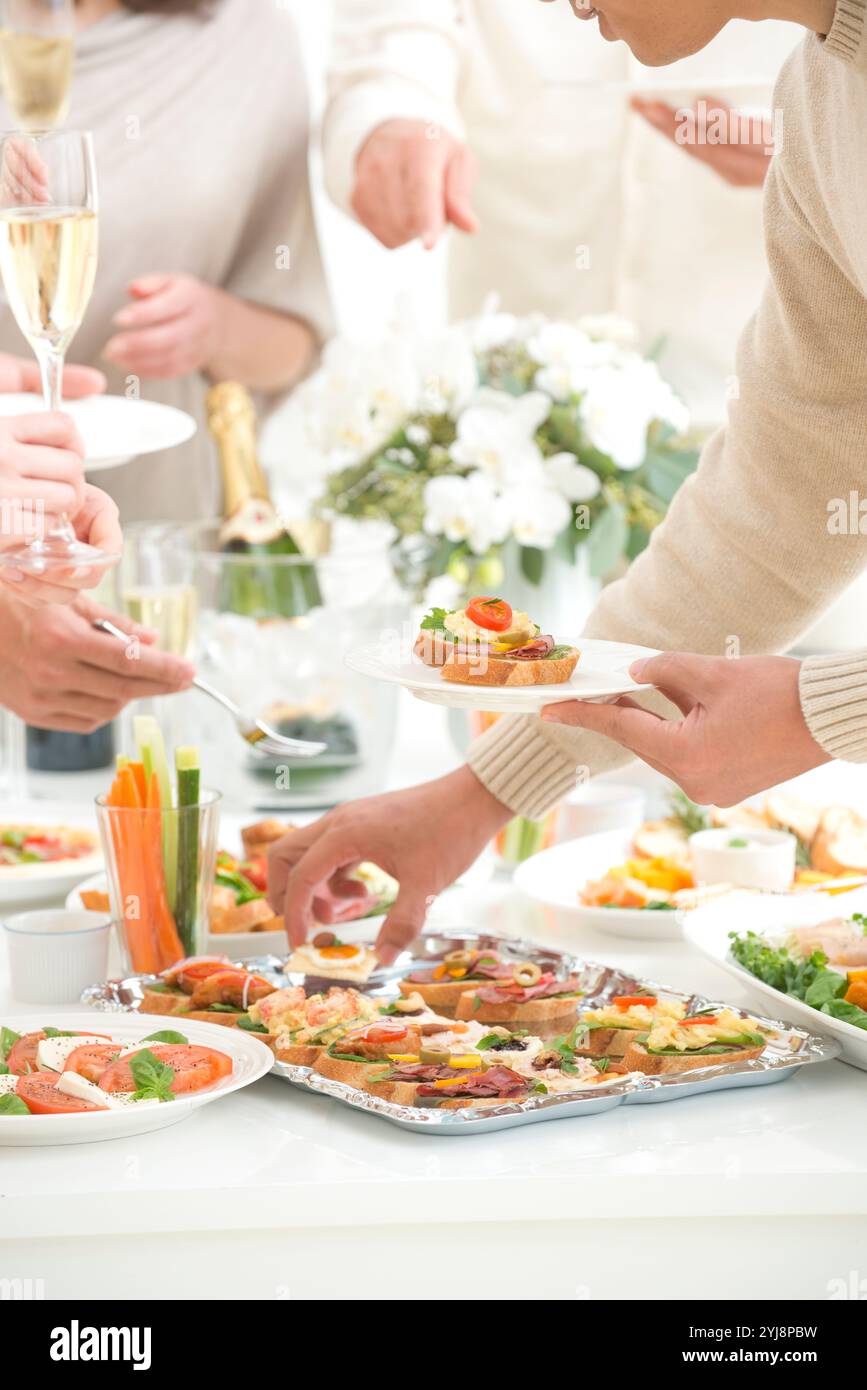 Leute essen Hors d'oeuvres auf einer Hausfeier Stockfoto