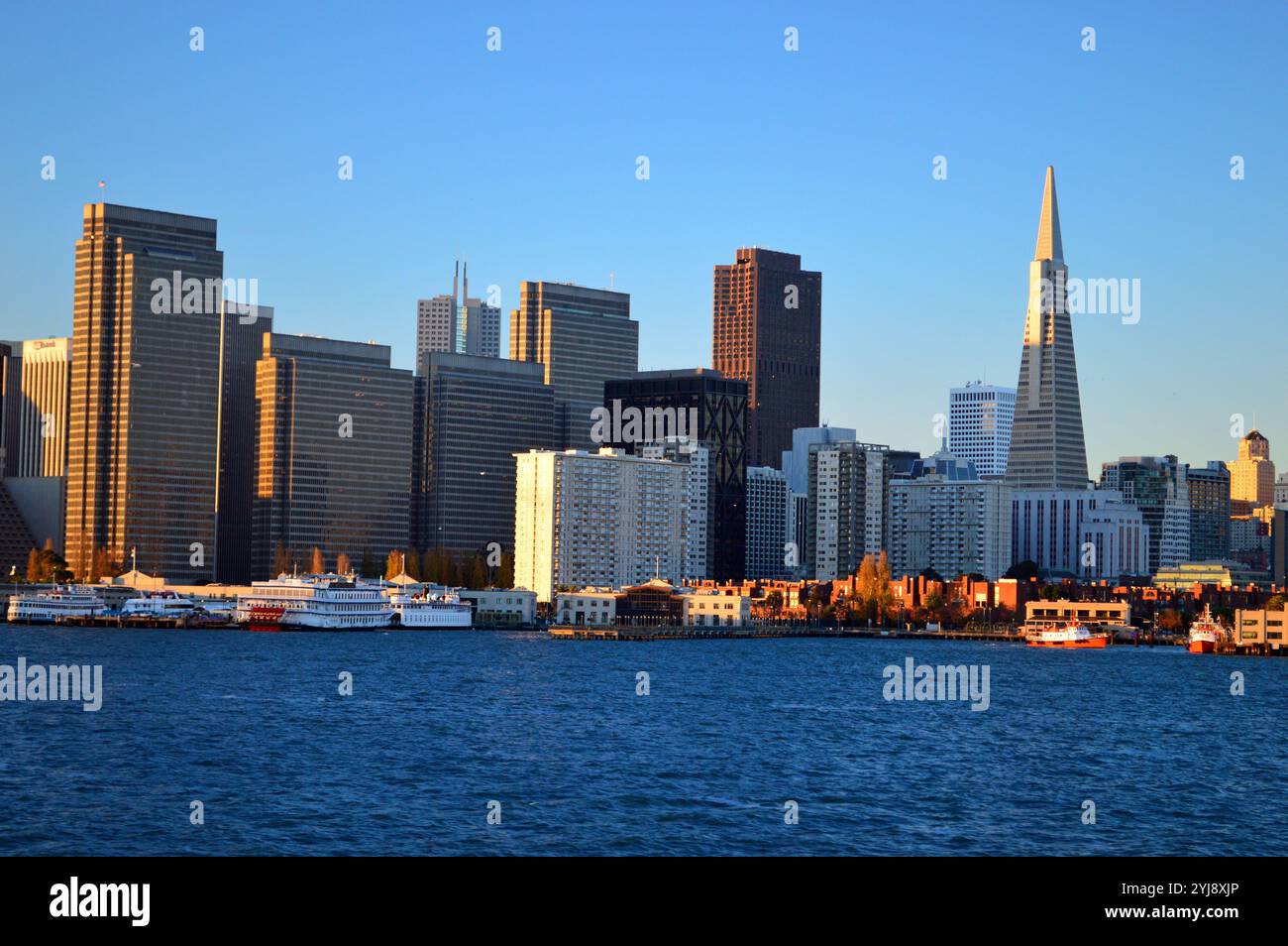 Die Skyline des Financial District von San Francisco mit der Transamerica Pyramid erhebt sich entlang der Bucht, von einer Fähre aus gesehen Stockfoto