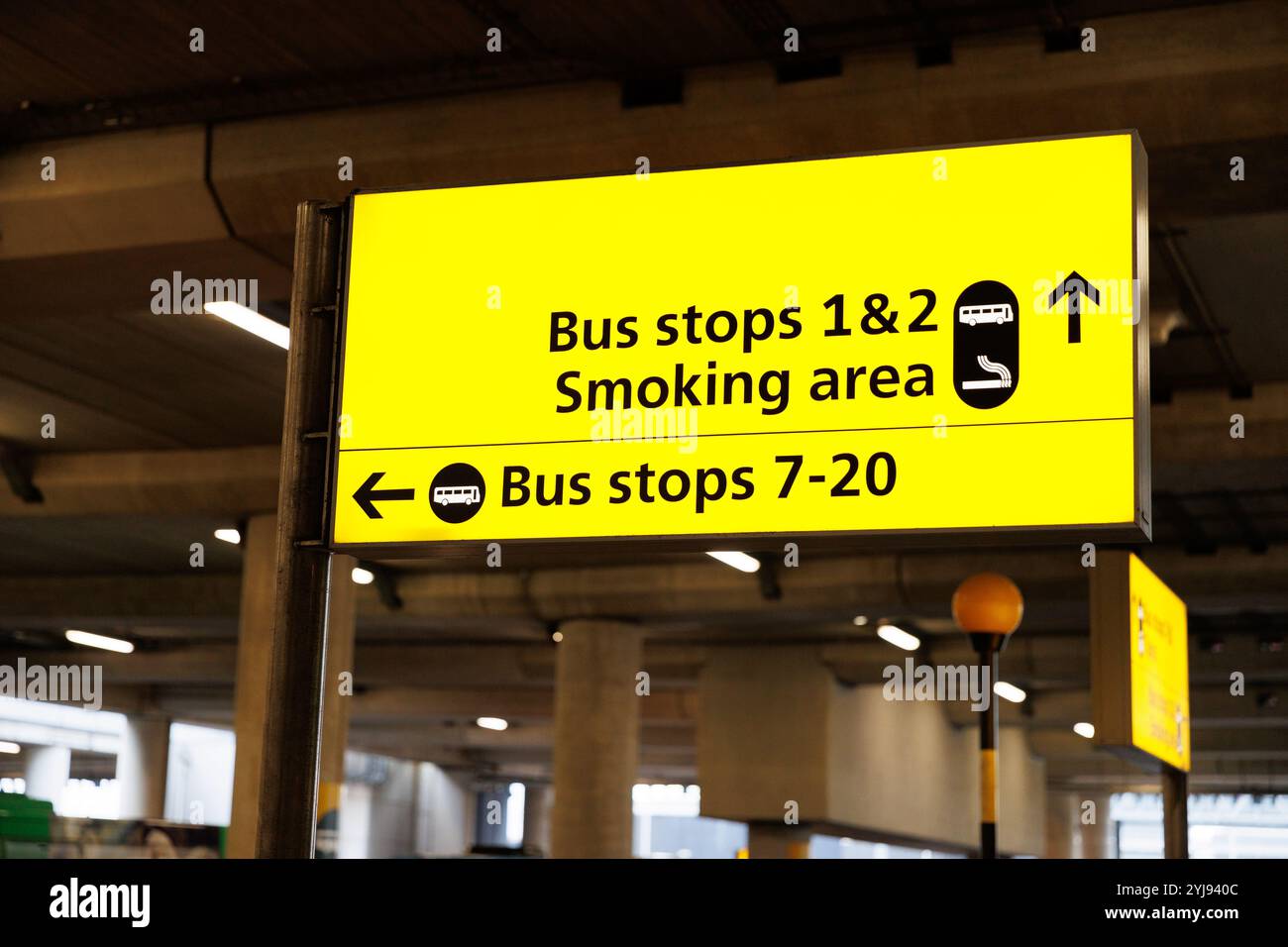 12. Nov. 2024. Ein Schild zum Busbahnhof und ein Raucherbereich am London Heathrow Terminal 3. Stockfoto