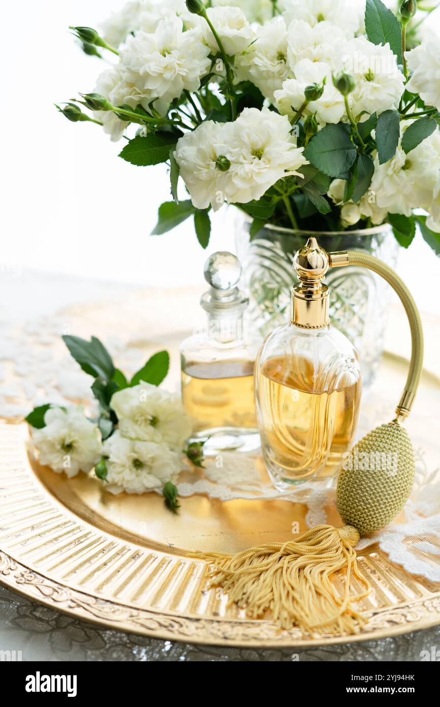 Klassische Parfümflasche und weiße Rosen Stockfoto